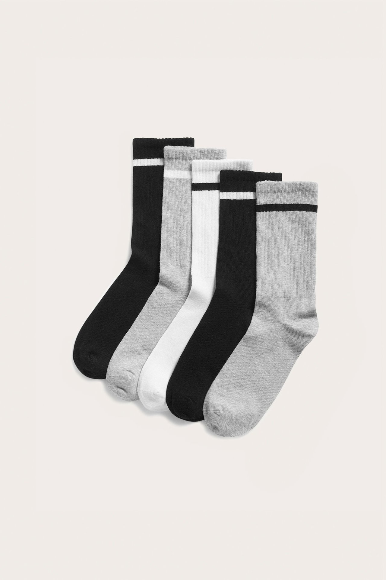 Forfra av 5-pakning blandede svarte, hvite og lysegrå ribbestrikkede sokker med stripete mansjetter.