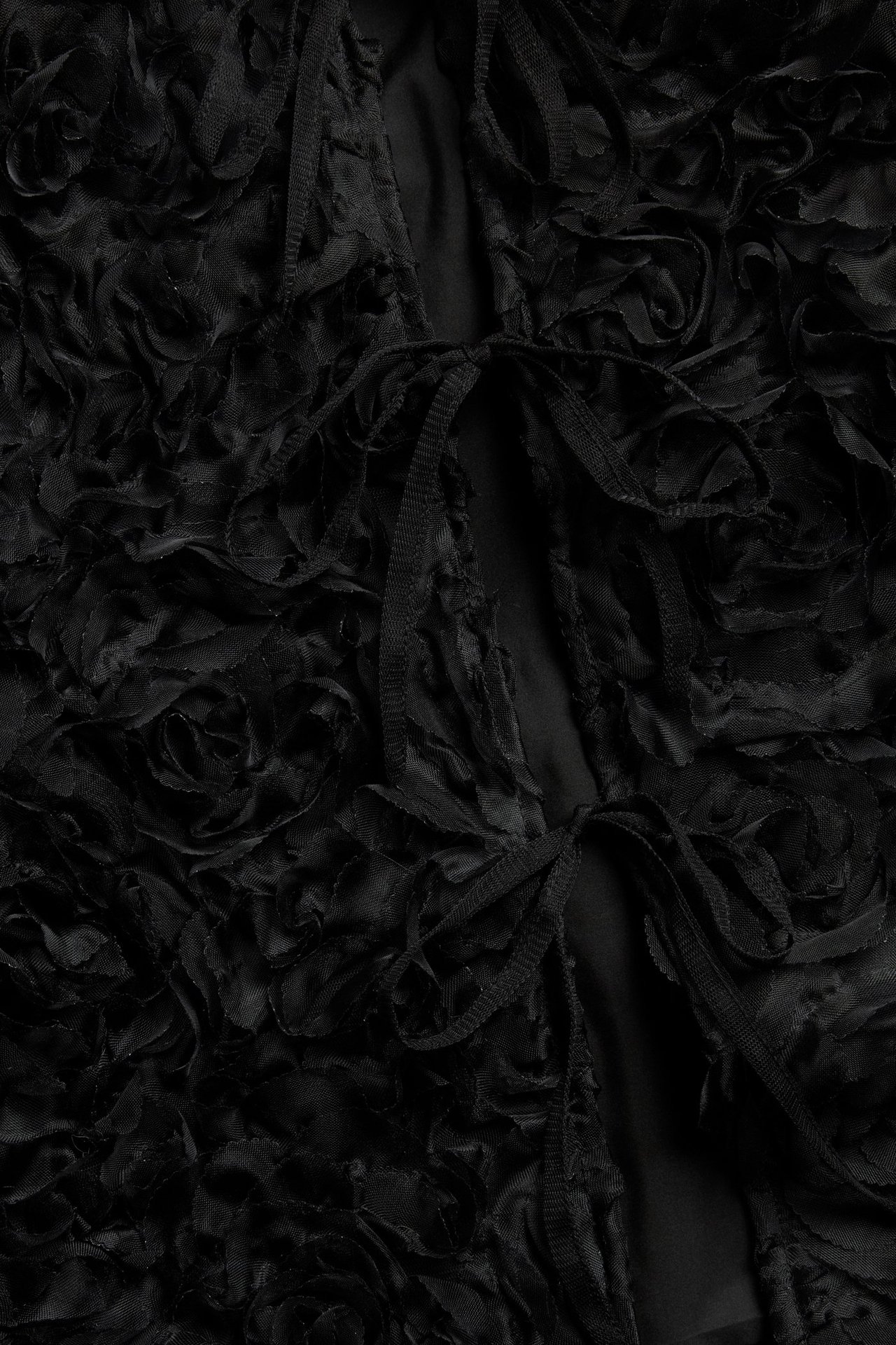 Czarna bluzka z bufiastymi rękawami i wiązaniem, jednokolorowa, na czarnej bluzce.