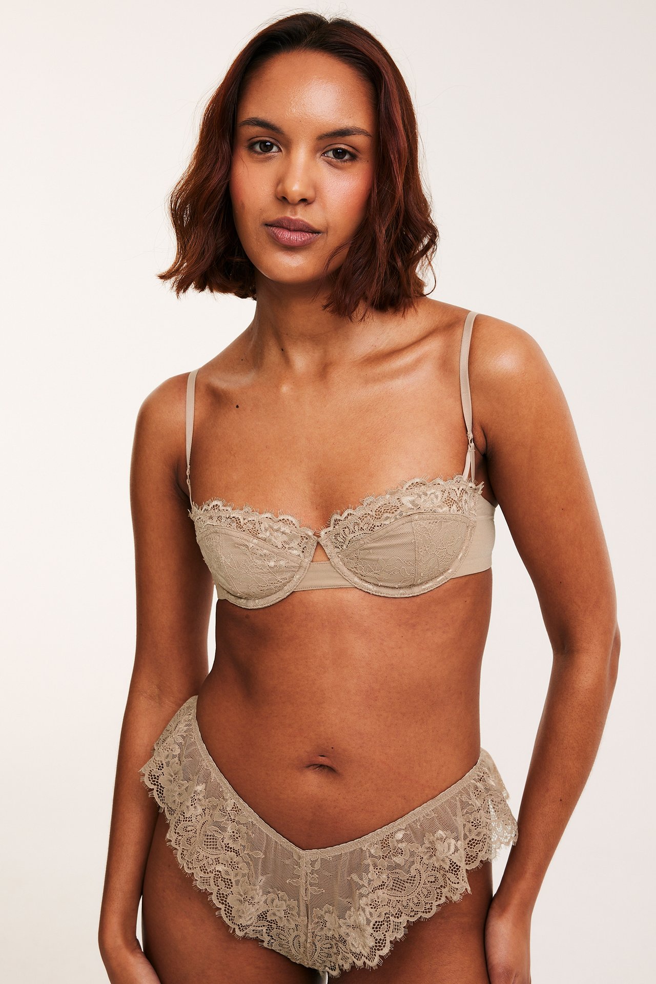 Forfra av kvinne i lysbrun blonde-balconette-bh og matchende blondetruse.