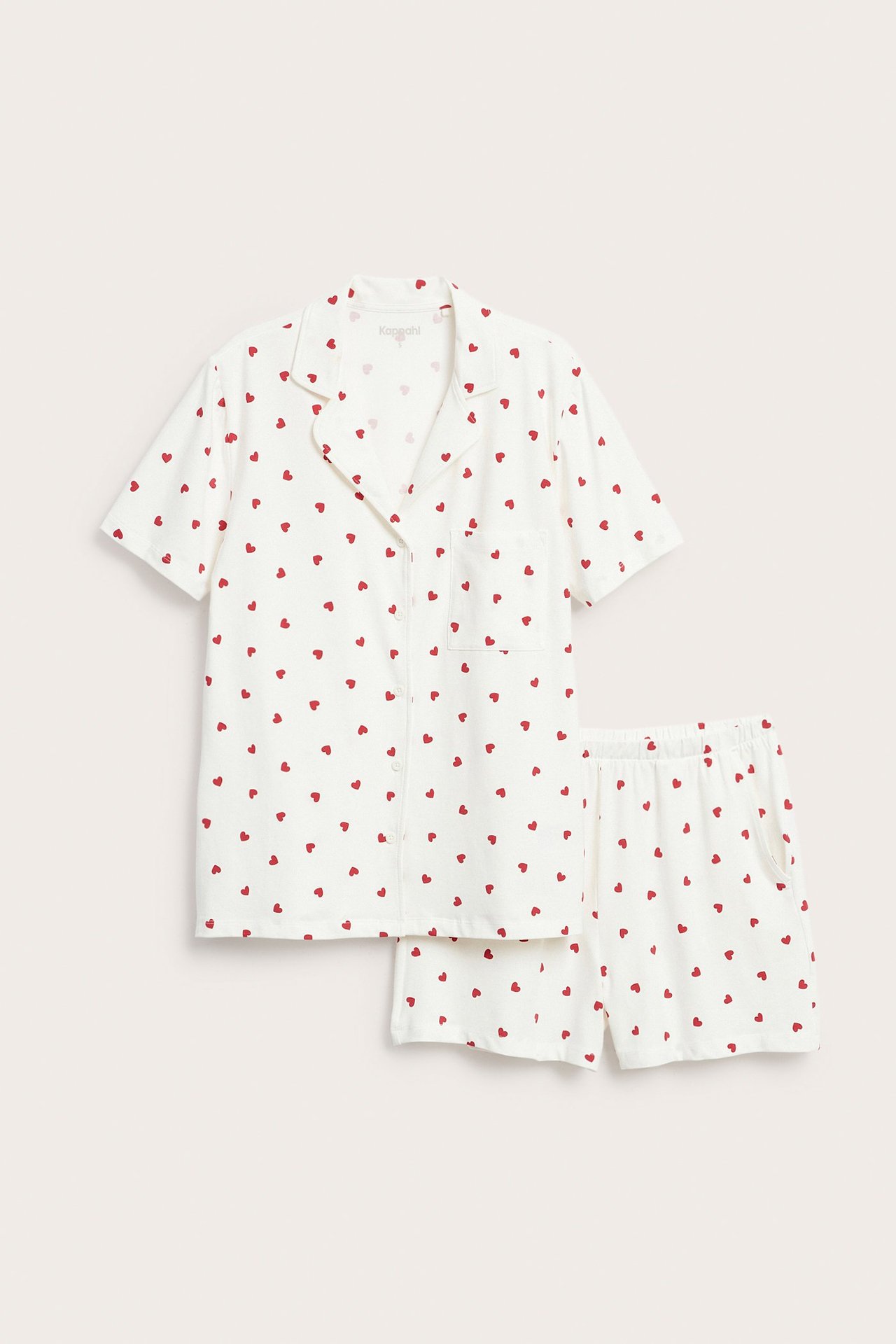 Framsida: Benvit pyjamas i bomullsblandning med röda hjärtan. Kortärmad topp, shorts med resårmidja.