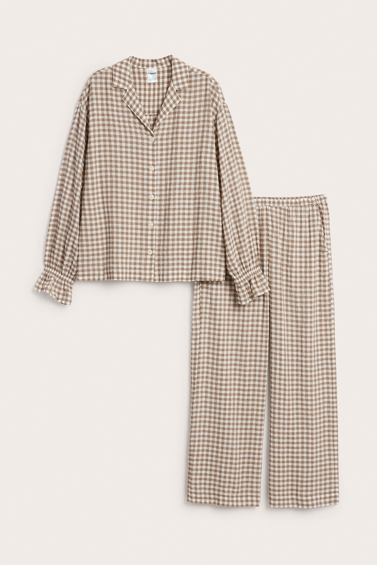 Forfra: Beige- og hvitrutet seersuckerpyjamas med knappet skjorte og vide bukser med elastisk midje.