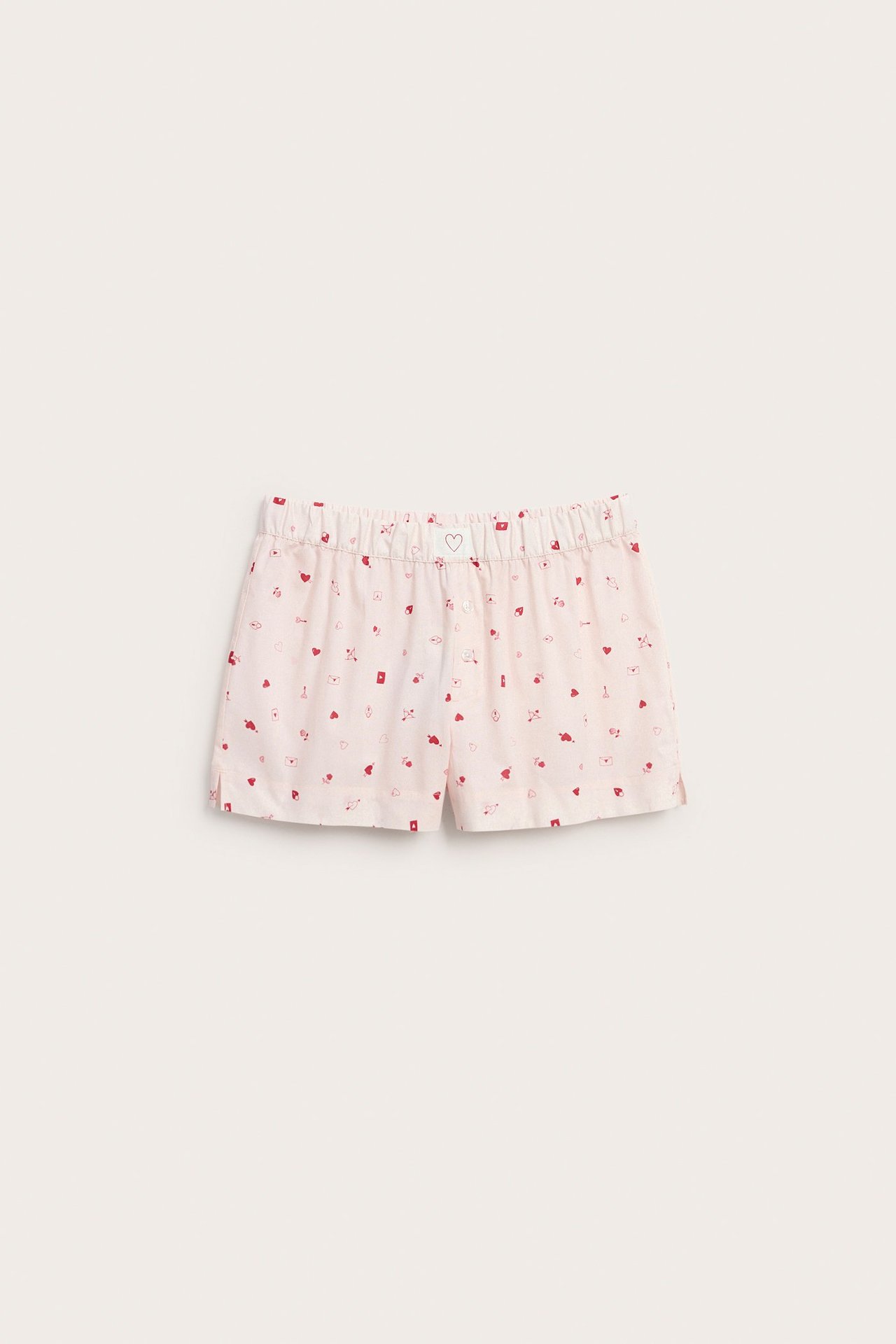 Frontbilde av lys rosa bomullspysjshorts med rødt hjertemønster, elastisk midje, dekorative knapper.