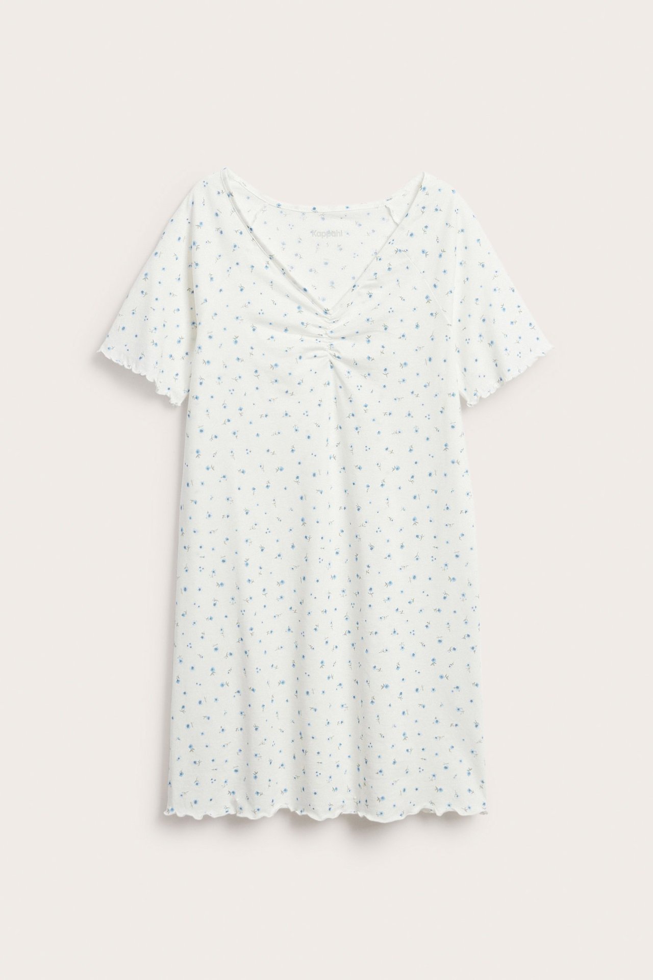 Framifrån: Vitt nattlinne i trikå med ljusblått blommönster, korta vågiga ärmar, rynkad V-ringning.
