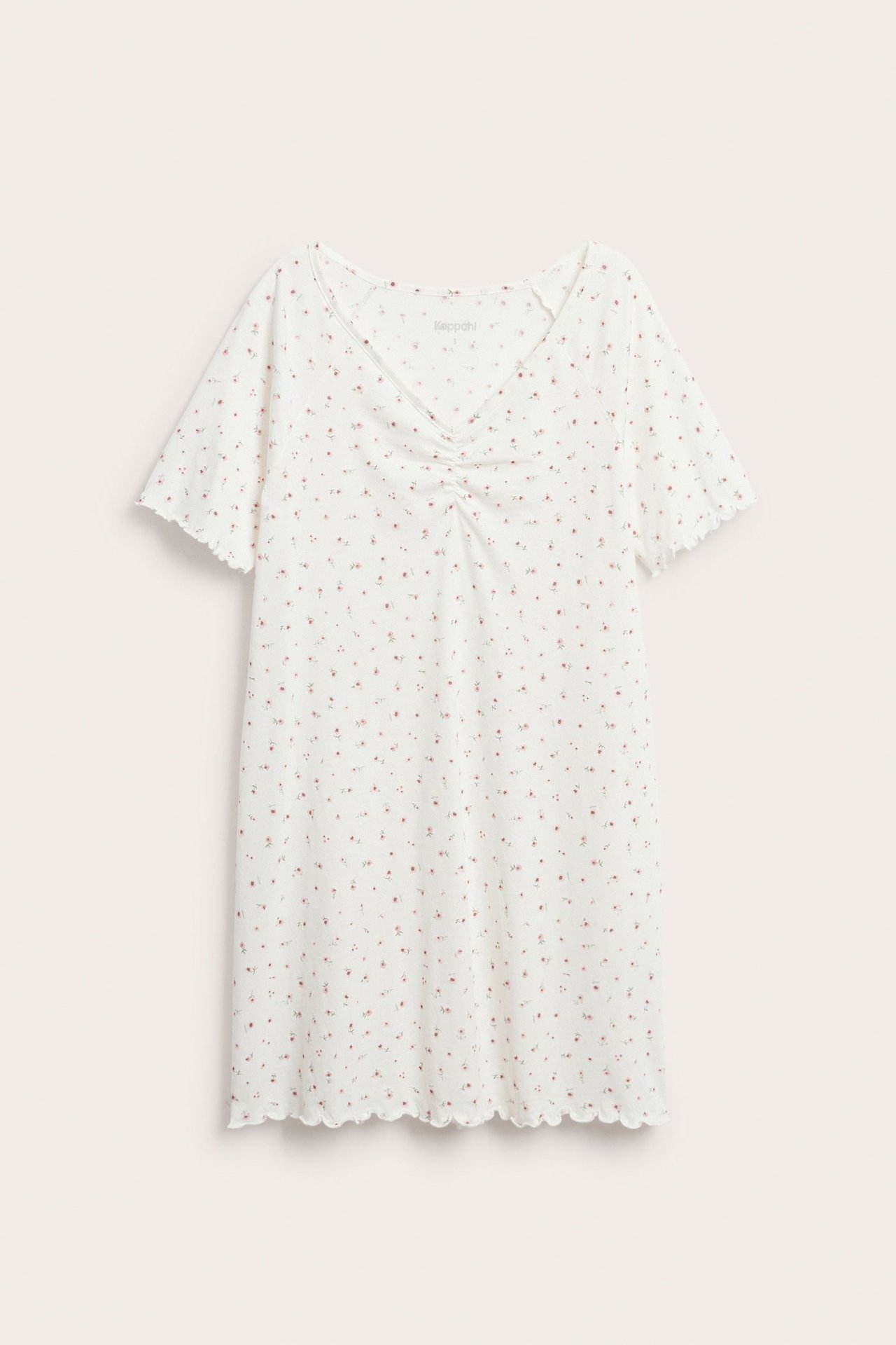 Frontvy: Vitt bomullsnattlinne med rosa blommönster, V-ringning, rynkdetalj och vågiga kanter.