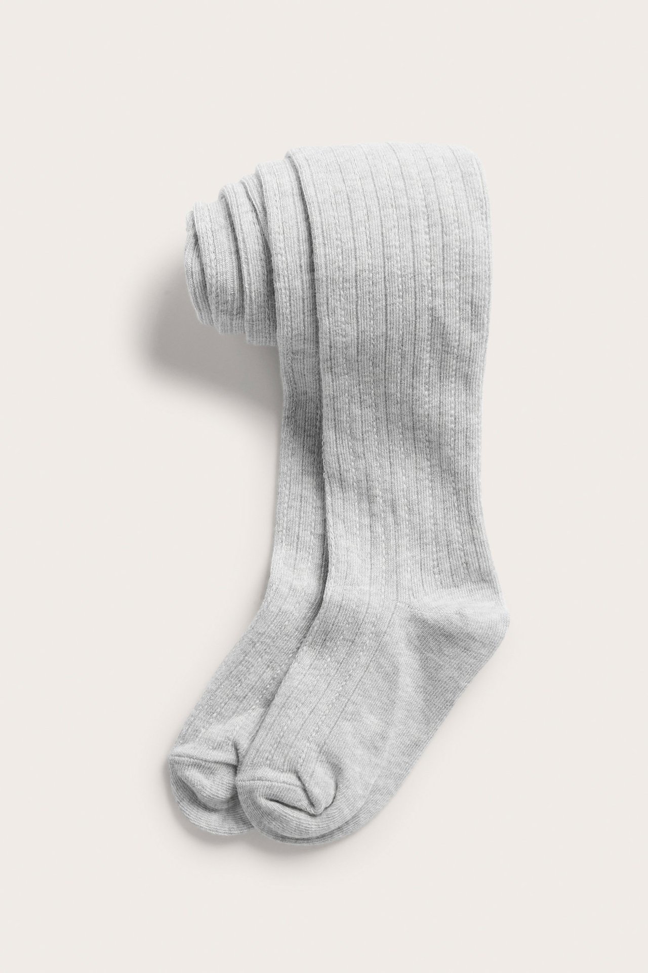 Widok z góry na złożone jasnoszare wzorzyste rajstopy dziecięce.