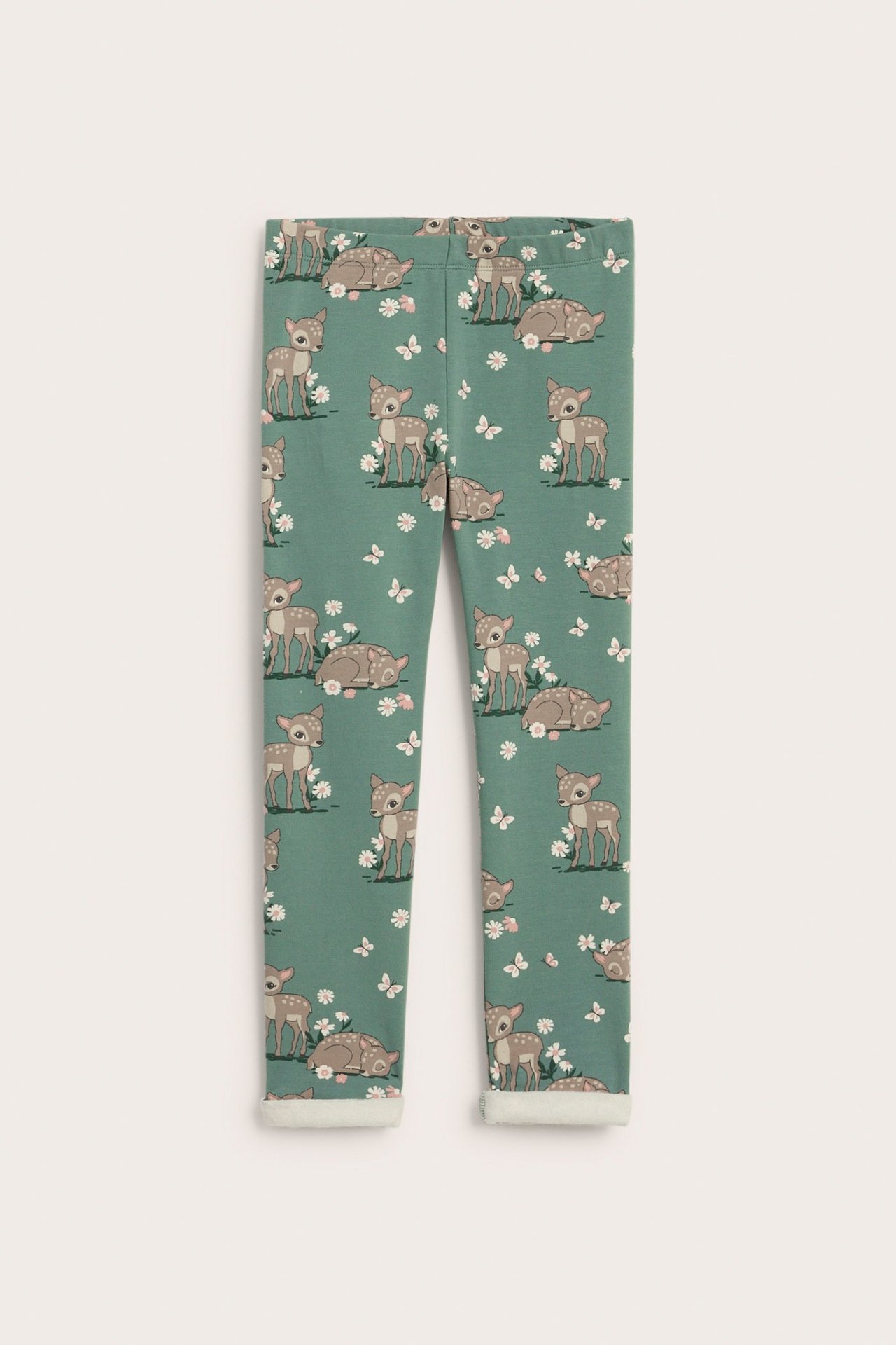 Widok z przodu zielonych legginsów dziecięcych we wzór saren, kwiatów i motyli, z podwiniętymi mankietami.