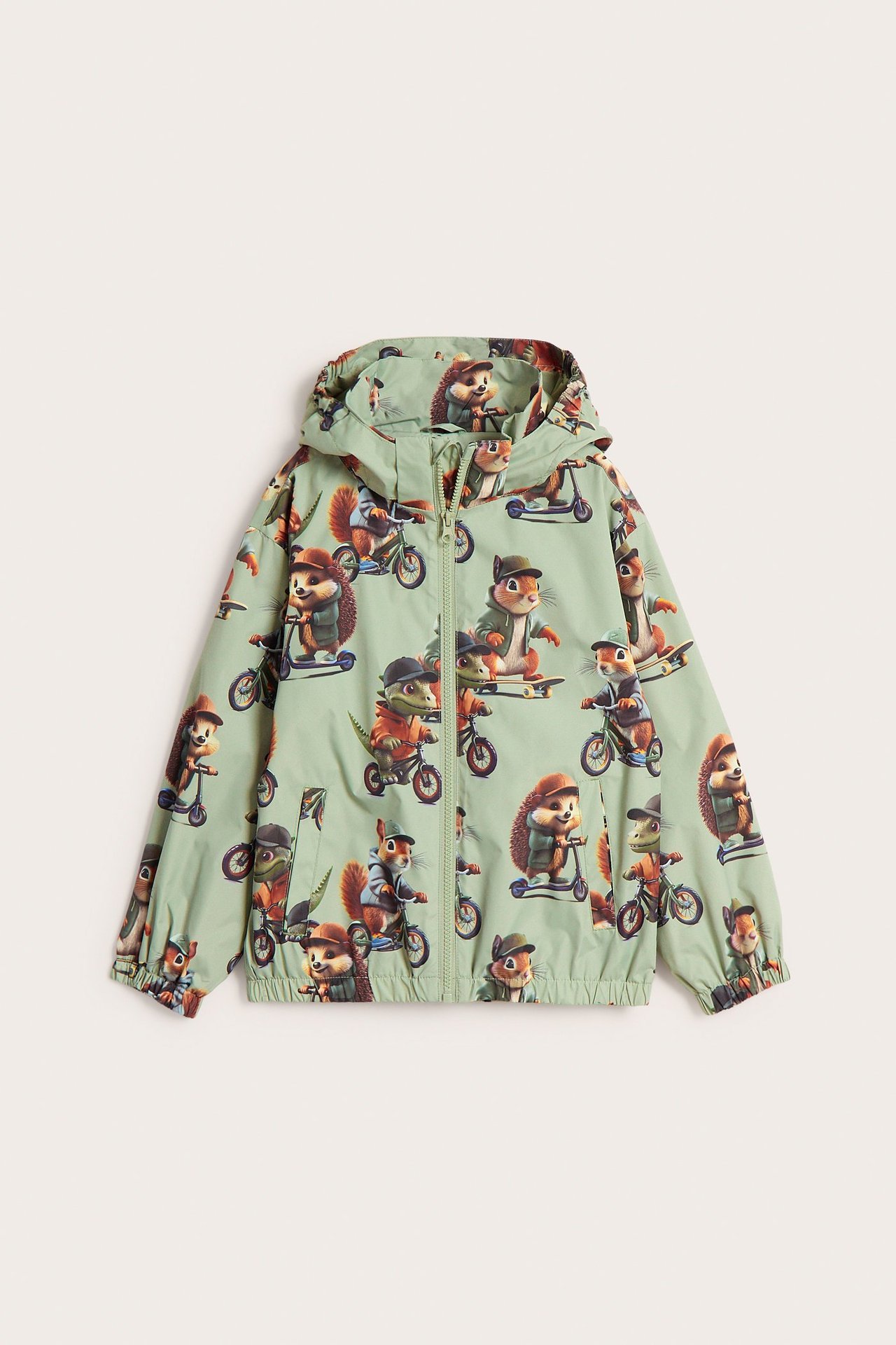 Edestä: Lasten vaaleanvihreä kuviollinen kuoritakki eläinaiheilla, hupulla ja vetoketjulla.