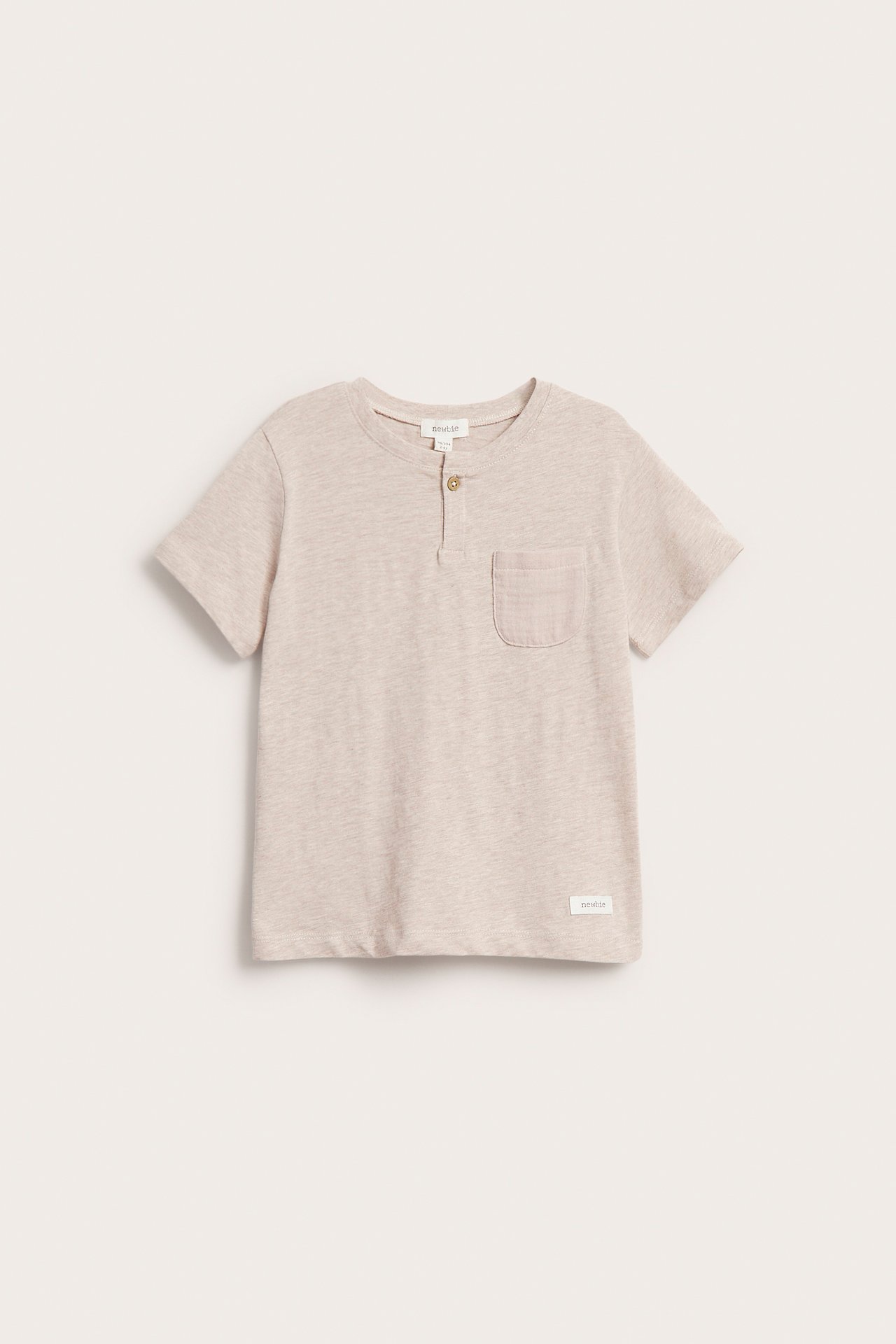 Framifrån: melerad beige t-shirt i slubtrikå för barn med kort ärm, bröstficka och en knapp.