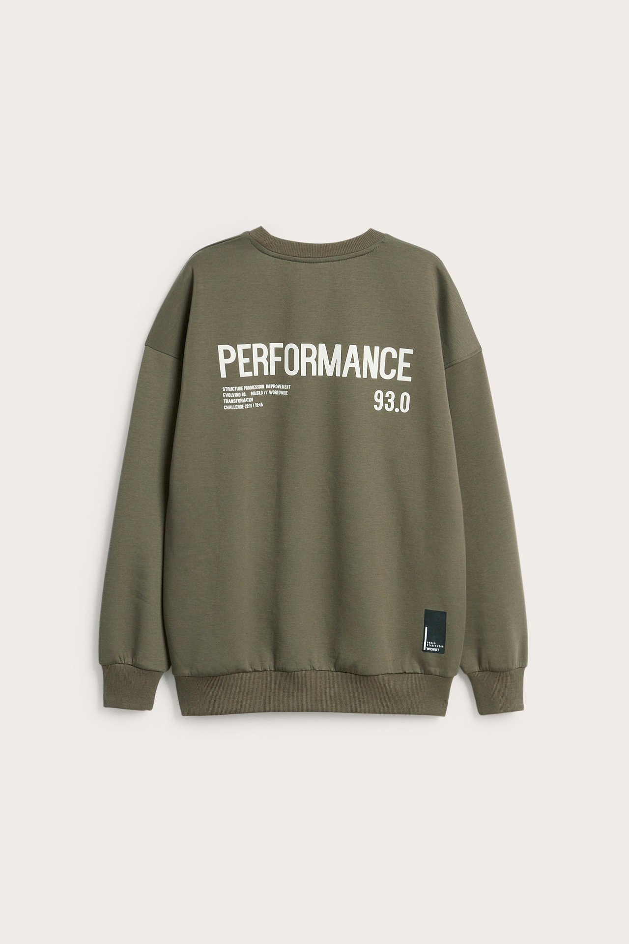 Widok z tyłu zielonej bluzy dresowej z interlocku z białym nadrukiem 'PERFORMANCE 93.0' na plecach.
