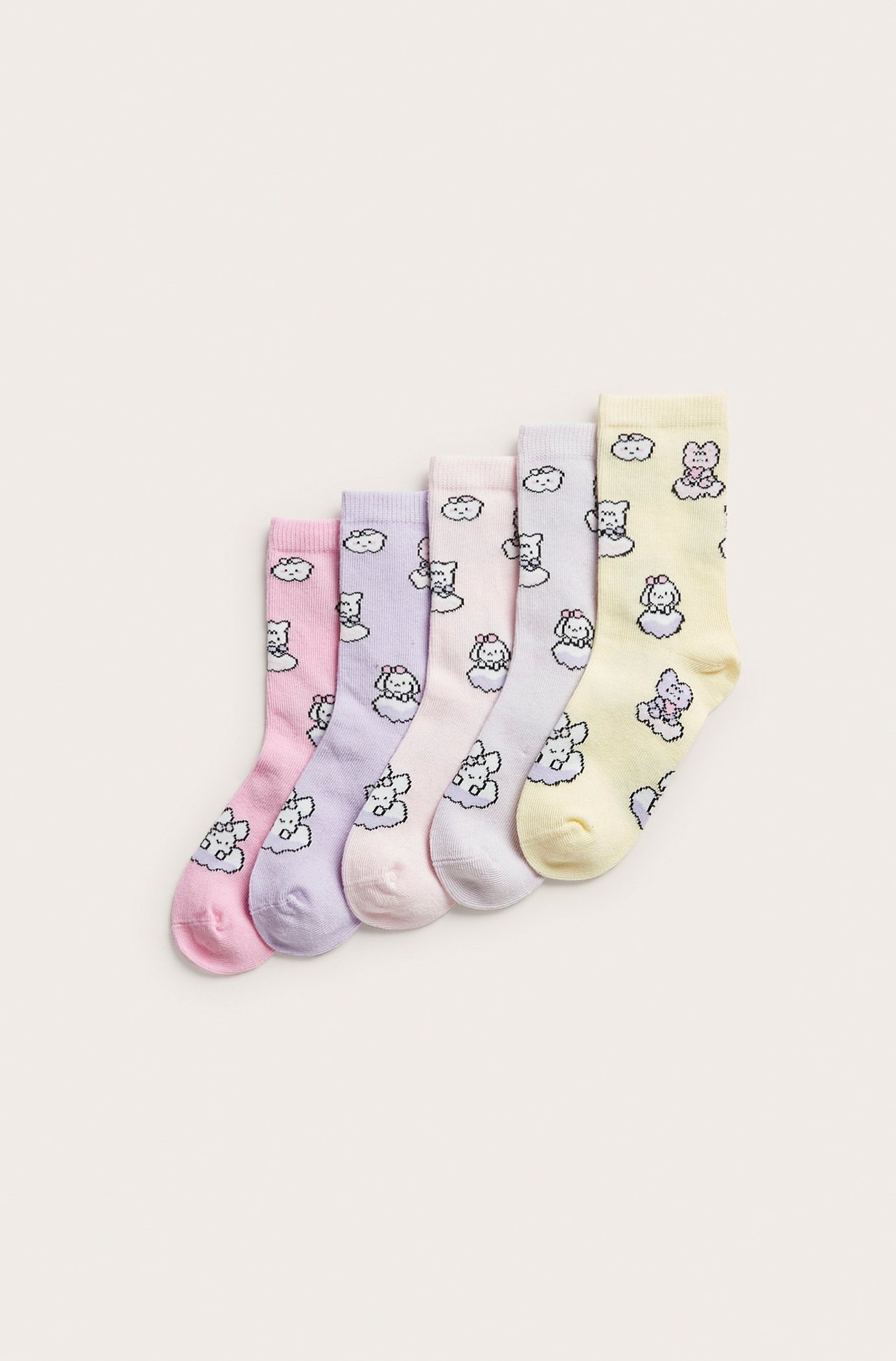 Uppifrånvy av fem mönstrade barnstrumpor i bomullsmix i ljusrosa, lila, beige, grå och gul.