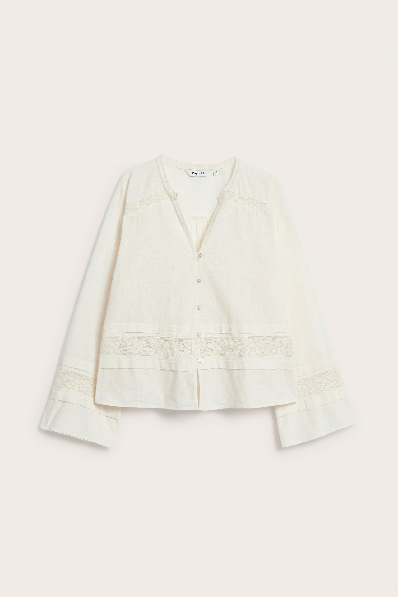 Framifrån: Offwhite bomullsblus med spetsdetaljer, kraglös V-ringning och knappar fram.