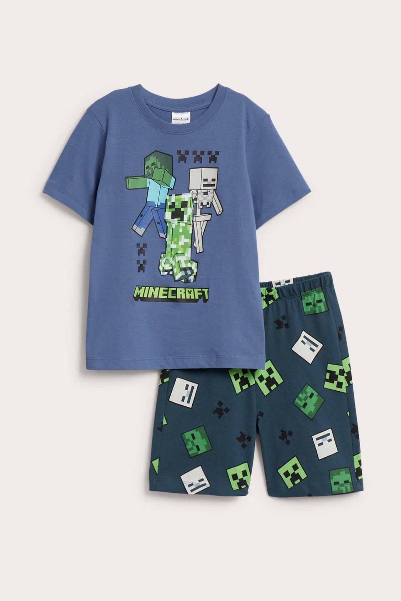 Frontvy av barns blå Minecraft bomullspyjamas: karaktärstryckt t-shirt och mörkblå mönstrade shorts.