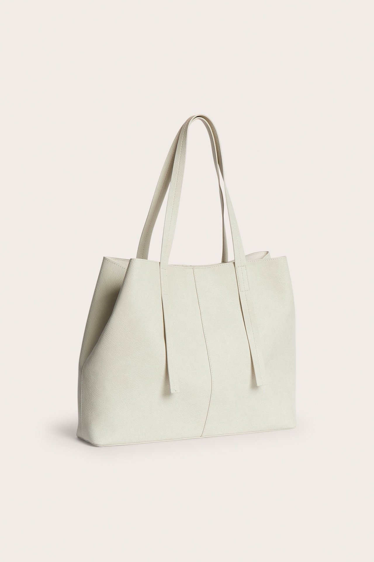 Widok z przodu beżowej torby typu tote ze imitacji skóry z dwoma uchwytami.