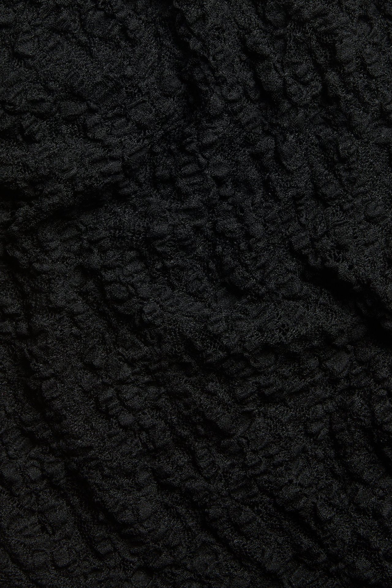 Zbliżenie na czarną koronkową tkaninę, ukazujące jej fakturę i wzór.