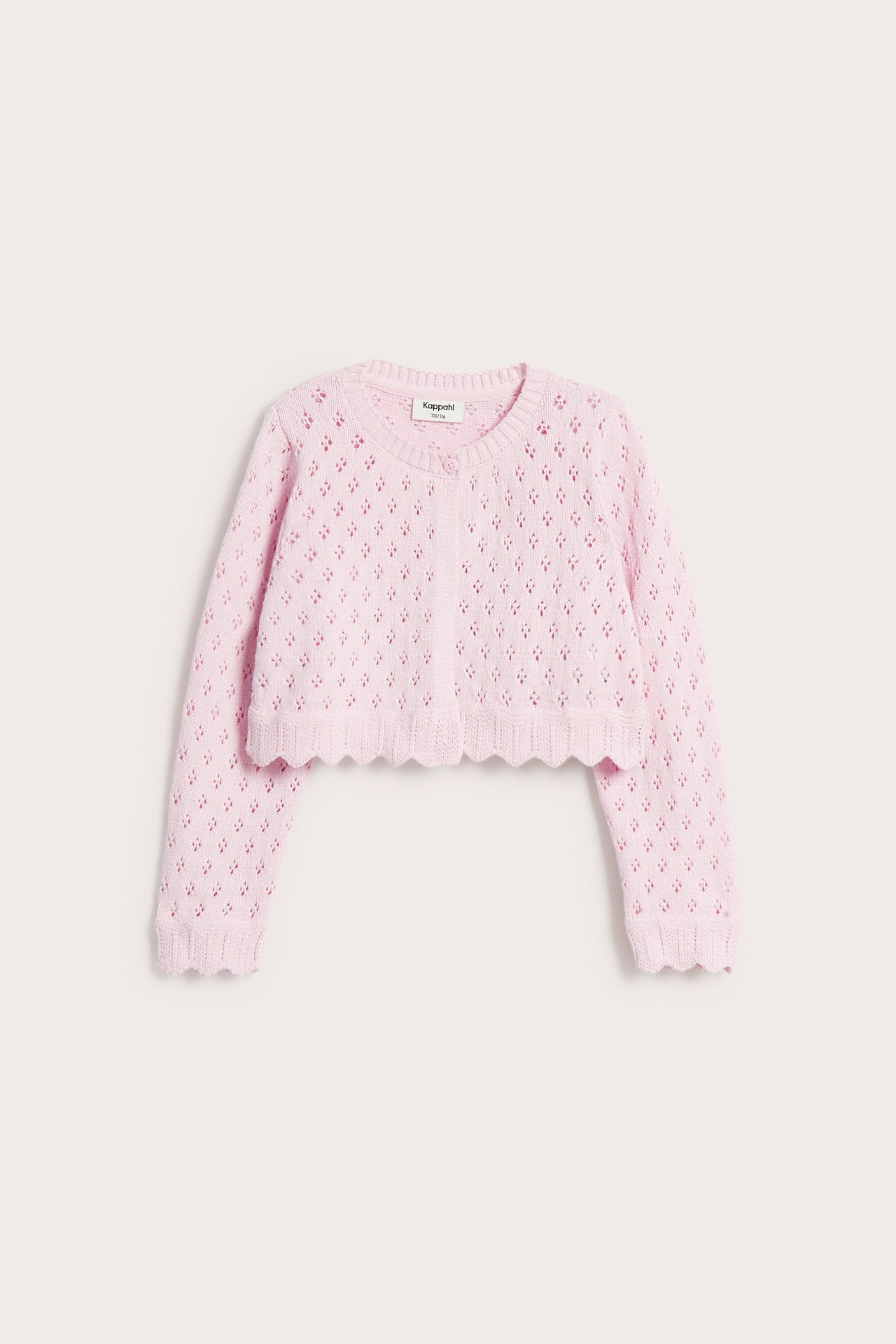 Framifrån: Ljusrosa mönsterstickad kofta i bomull med vågiga kanter och en knapp.