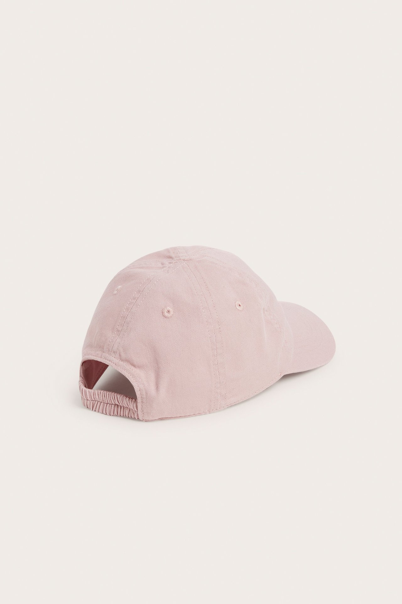 Takasivukuva vaaleanpunaisesta luomupuuvillaisesta lasten lippiksestä, jossa on joustava takaosa.