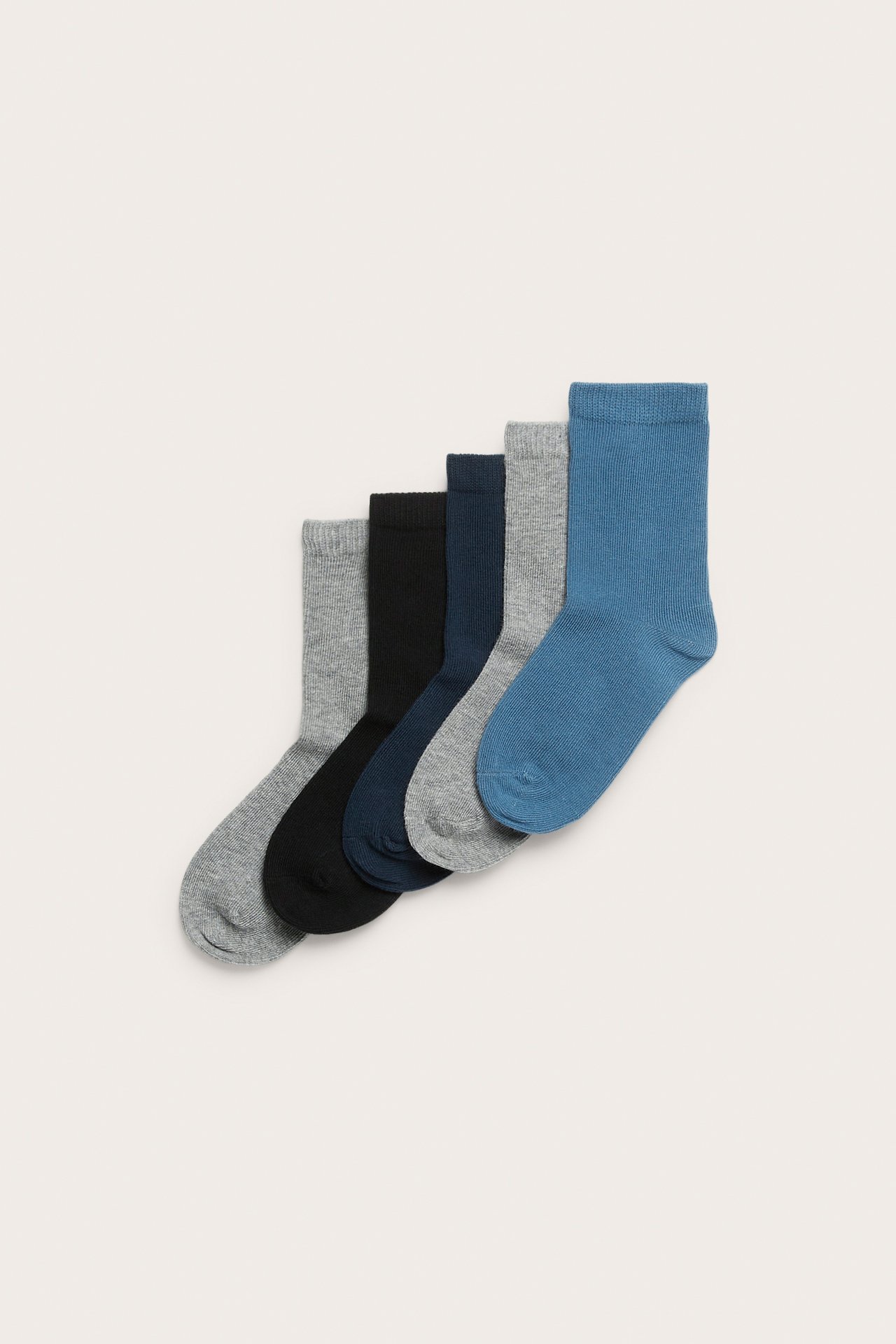 Ovanifrån, fem enfärgade strumpor i bomullsblandning: blå, mellangrå, mörkblå, svart och ljusgrå.