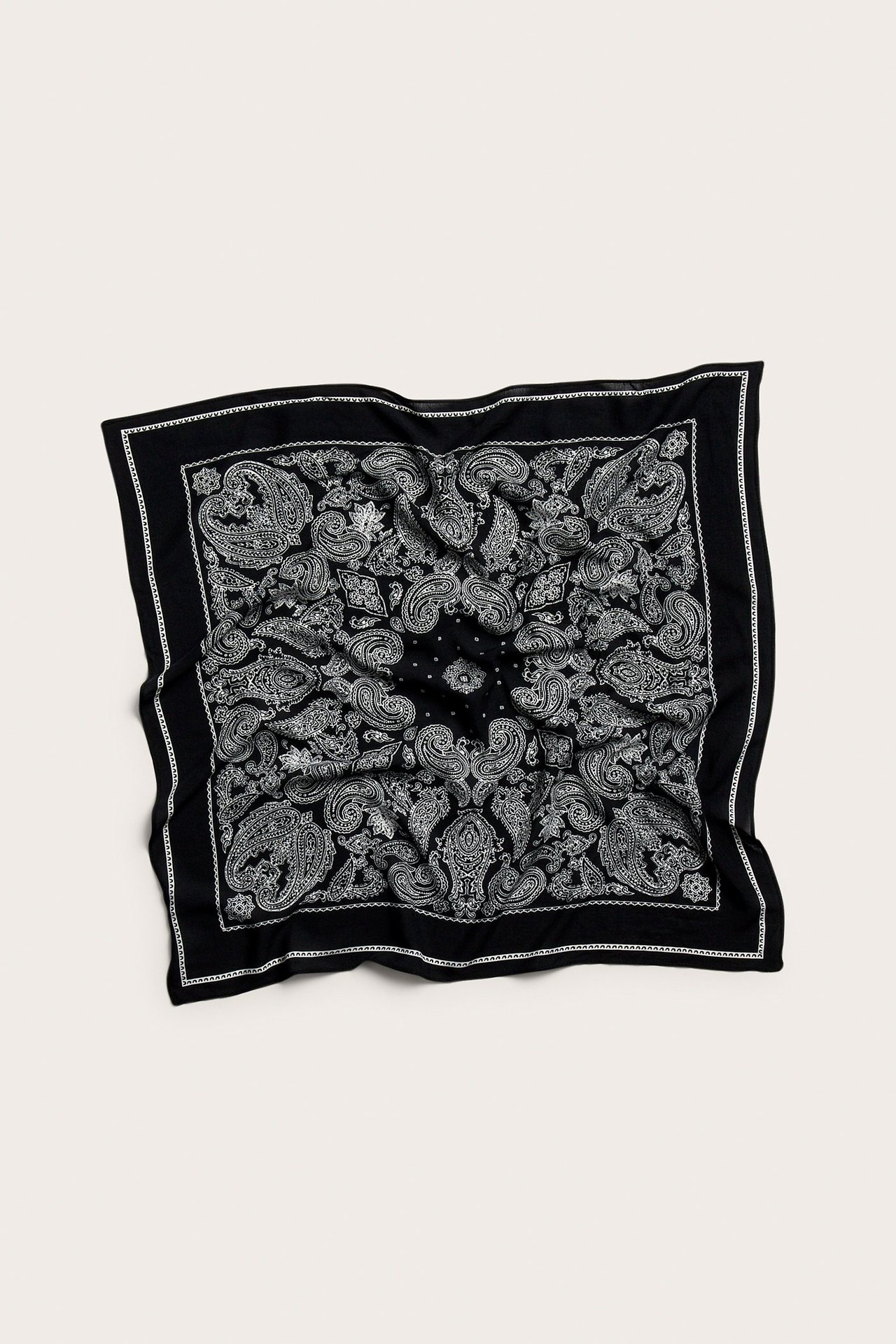 Ylhäältä näkymä mustasta neliönmuotoisesta huivista, jossa valkoinen paisleymainen kuvio, pehmeää viskoosisekoitetta.