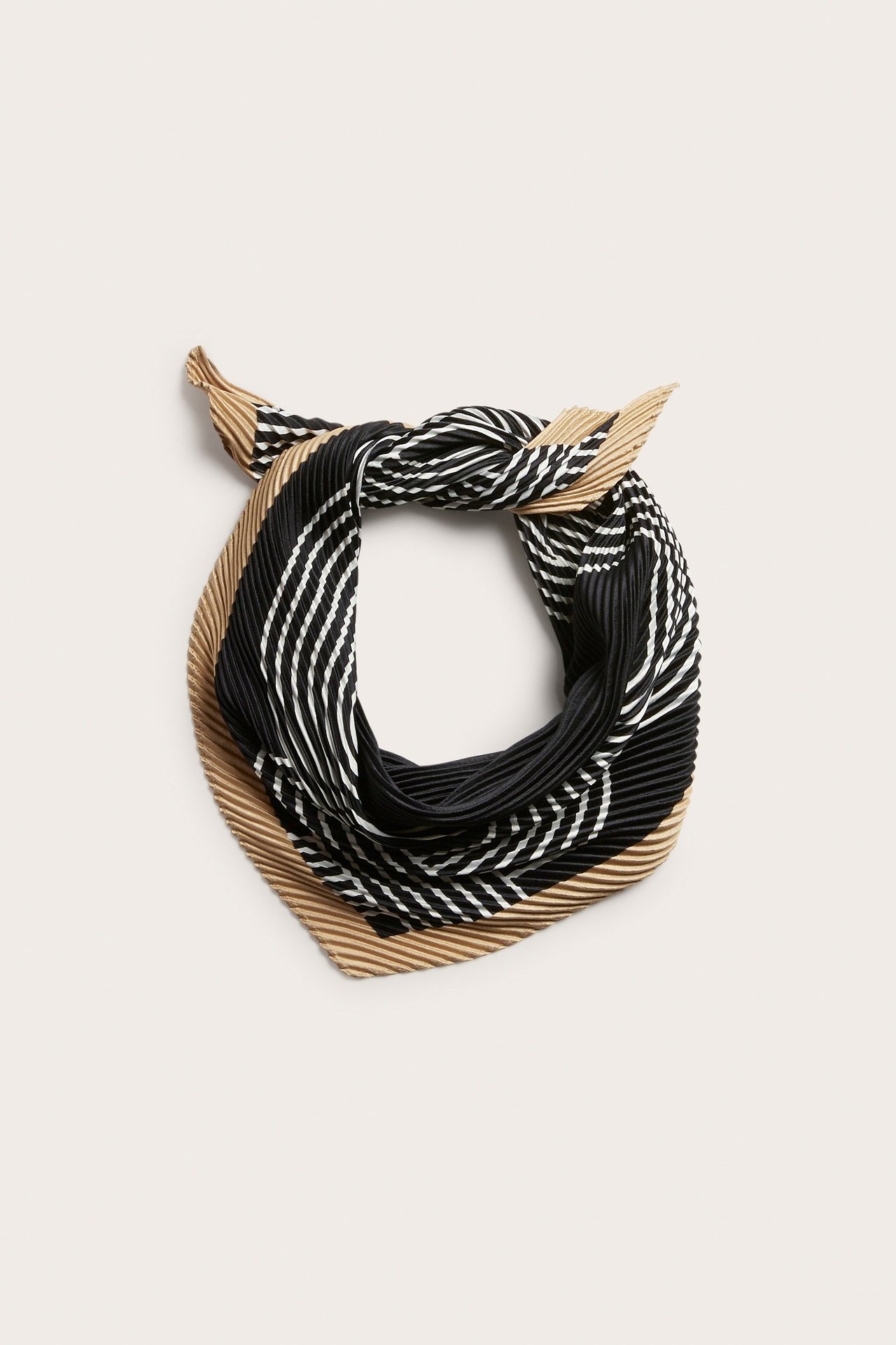 Övervy av en svart, vit och beige plisserad scarf med randigt mönster, knuten.