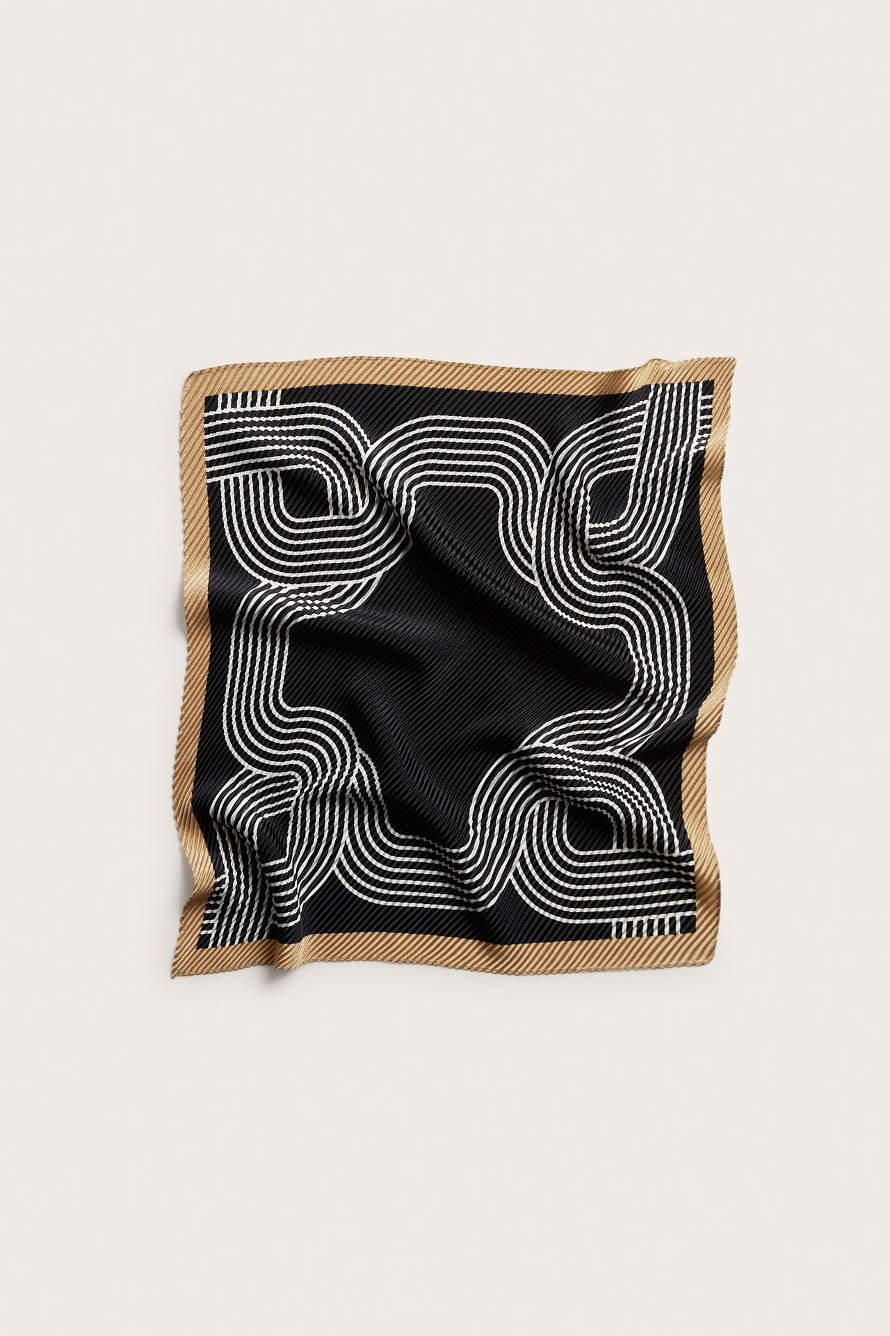 Toppvy av en veckad fyrkantig svart polyesterscarf med vitt abstrakt mönster och beigefärgad bård.