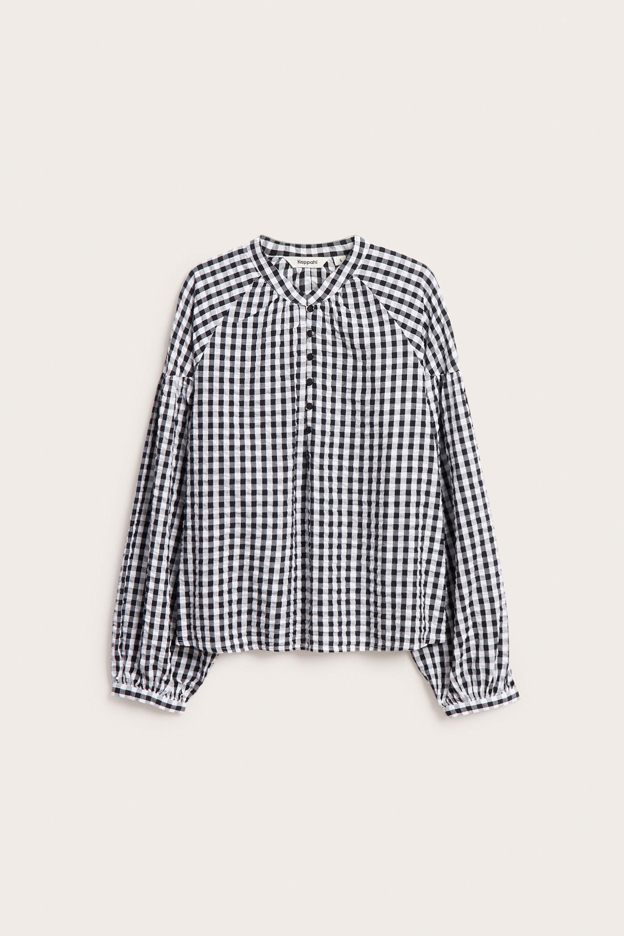 Frontvisning av en svart-hvit rutete seersucker-bluse med knapper foran og puffermer.