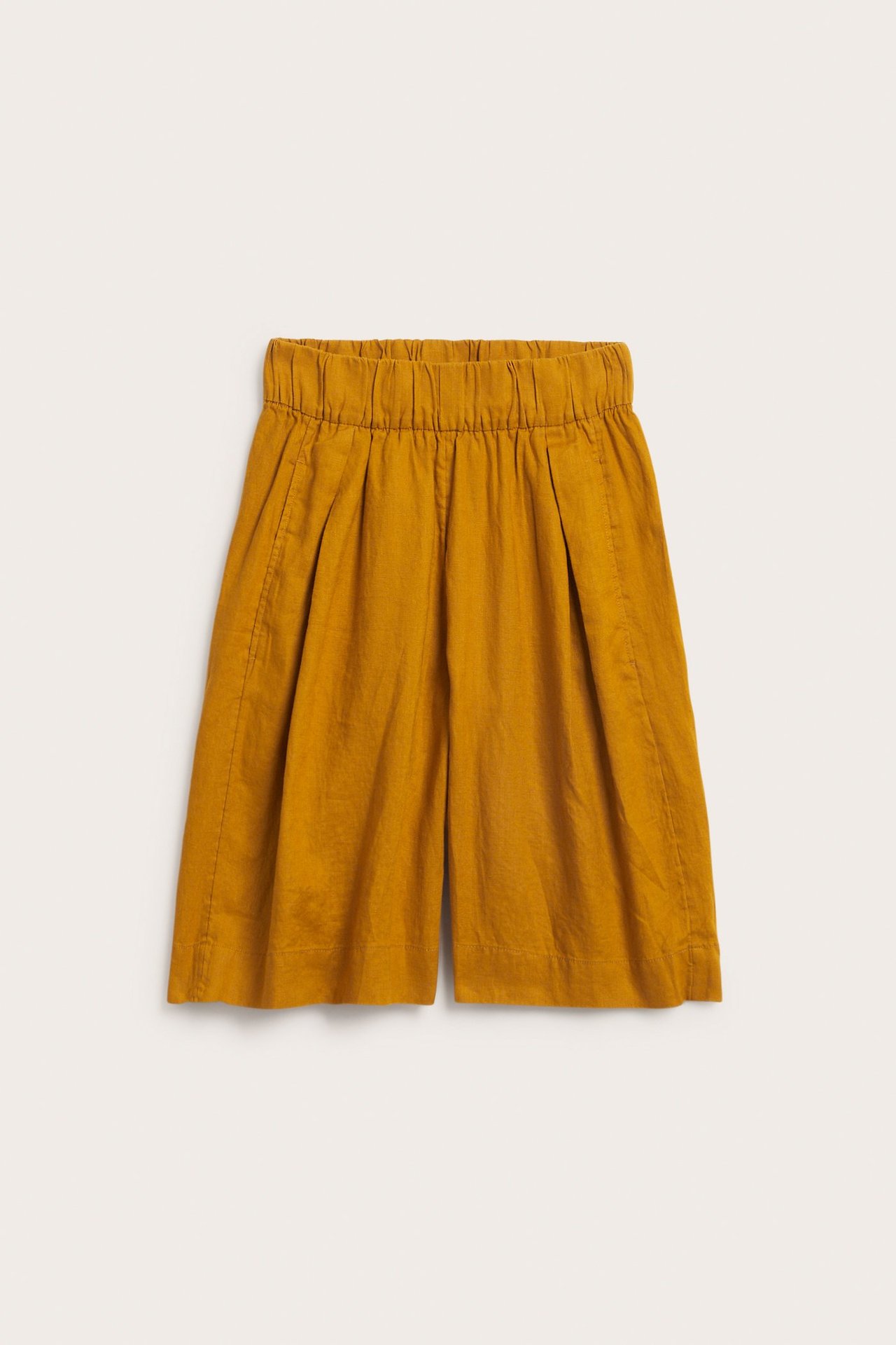 Edestä: keltaiset pellavaiset polvipituiset shortsit, joissa joustava vyötärö ja sivutaskut.