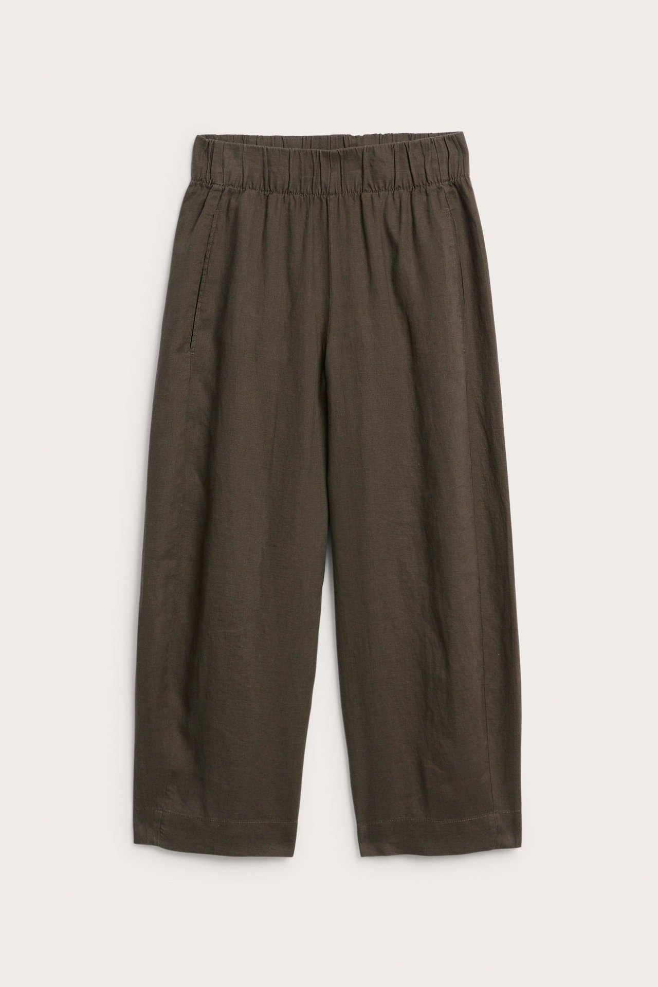 Widok z przodu ciemnobrązowych lnianych spodni barrel leg z elastyczną talią i kieszeniami bocznymi.