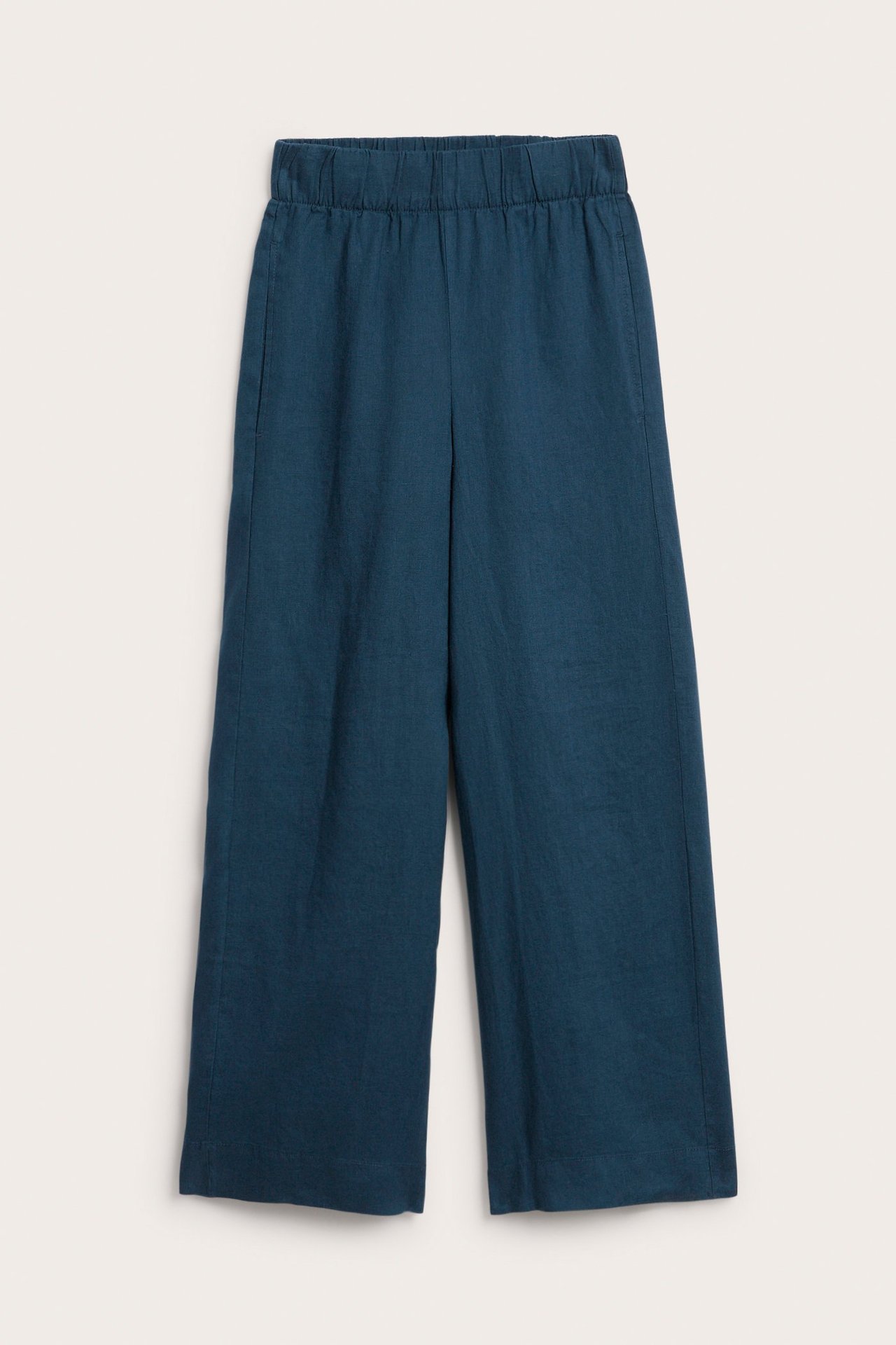 Widok z przodu granatowych lnianych spodni z prostymi nogawkami, elastyczną talią i kieszeniami bocznymi.