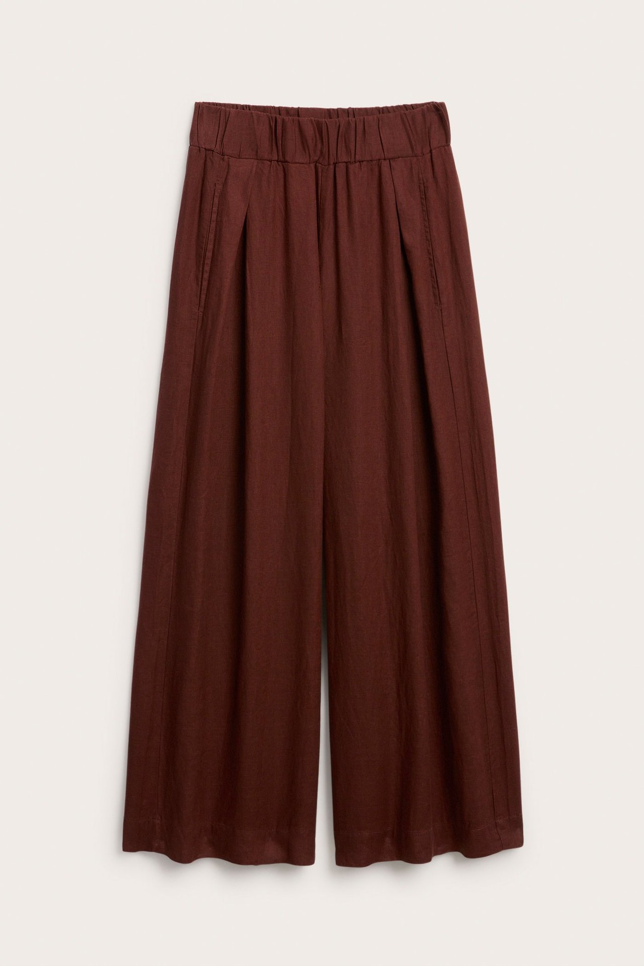 Frontbilde av ensfargede vinrøde linbukser med vide ben, elastisk linning, legg foran og sidelommer.