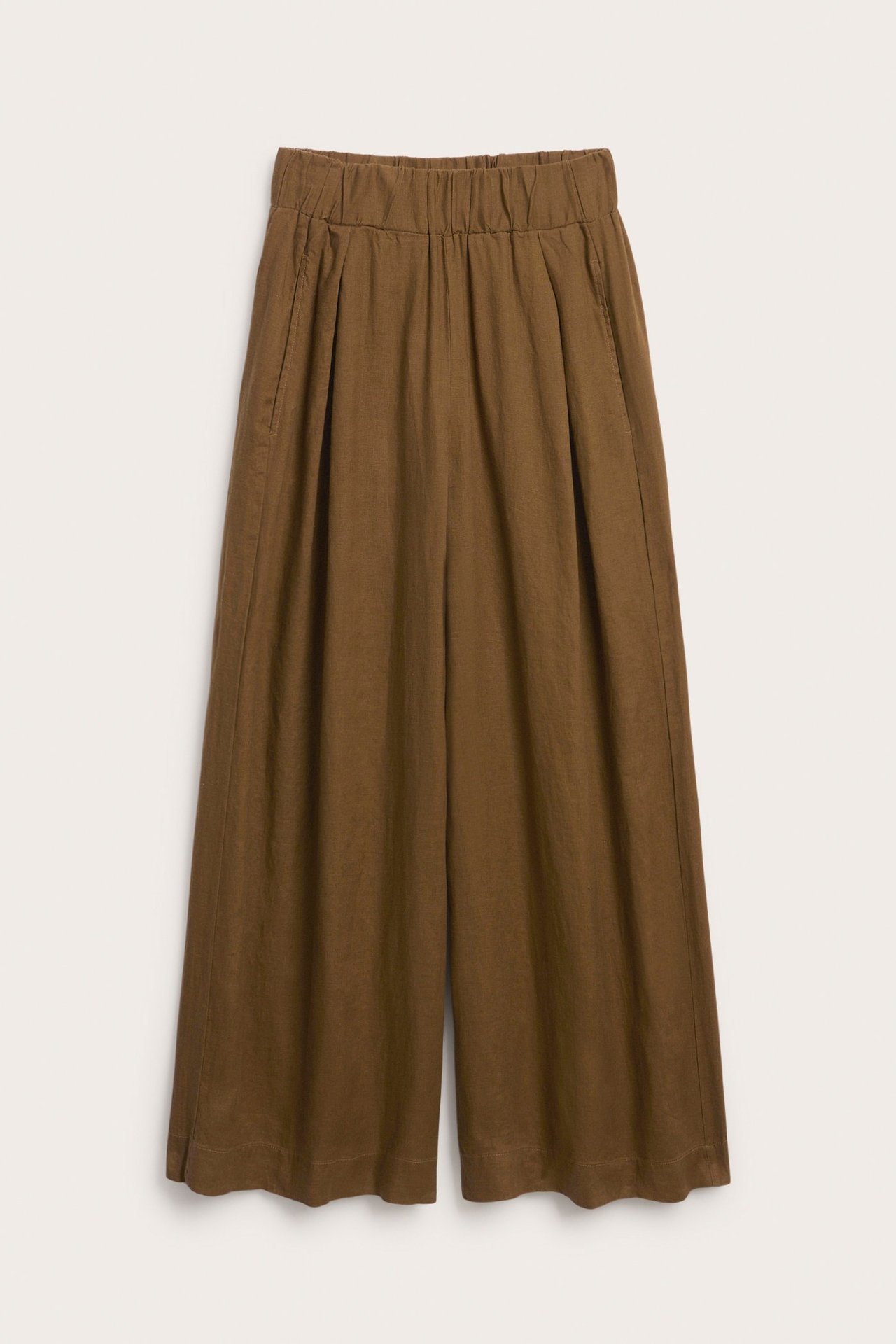 Widok z przodu: Brązowe, szerokie spodnie lniane z elastyczną talią, zaszewkami i kieszeniami bocznymi.