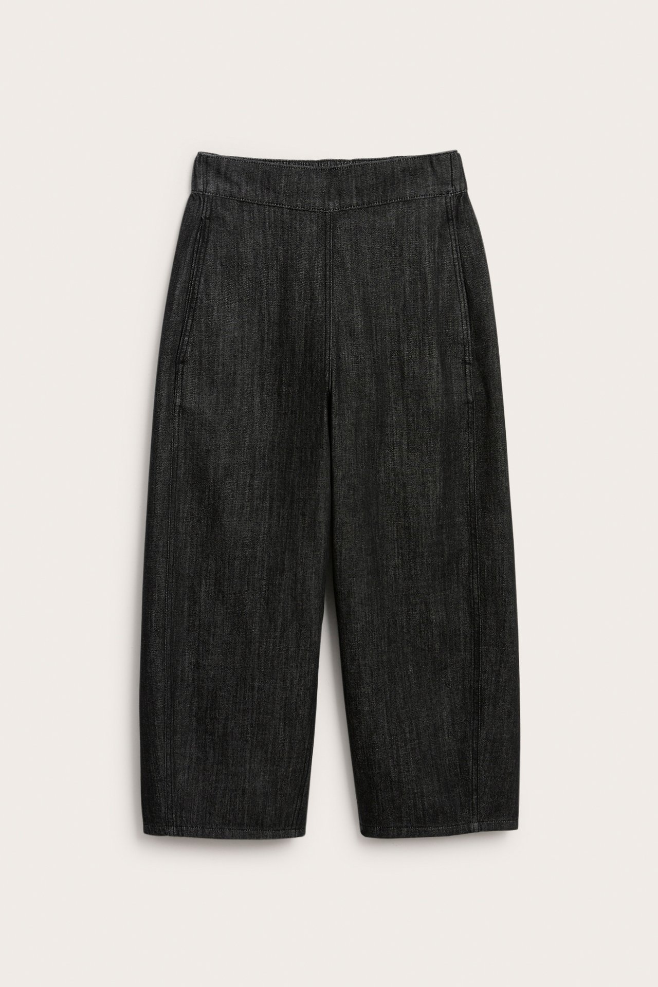 Edestä mustat denim barrel fit -vetoketjuttomat farkut, sivutaskut ja näkyvät ompeleet.