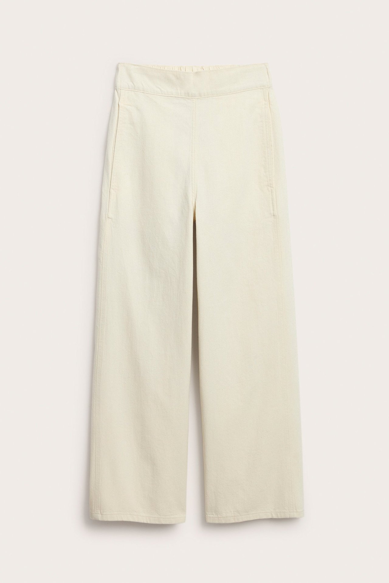 Frontvisning av beige rette bomullsjeans med elastisk midje og sidelommer.