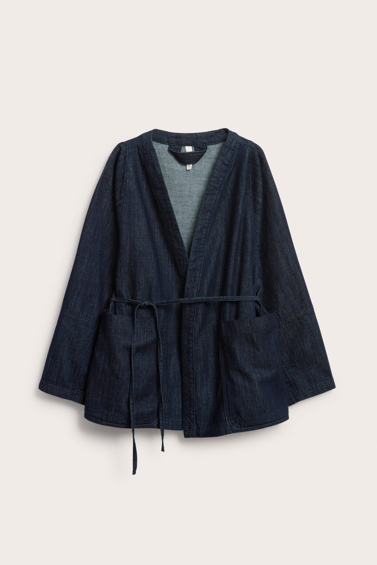 Widok z przodu ciemnej kurtki dżinsowej kimono z wiązanym paskiem i dwiema dużymi kieszeniami.