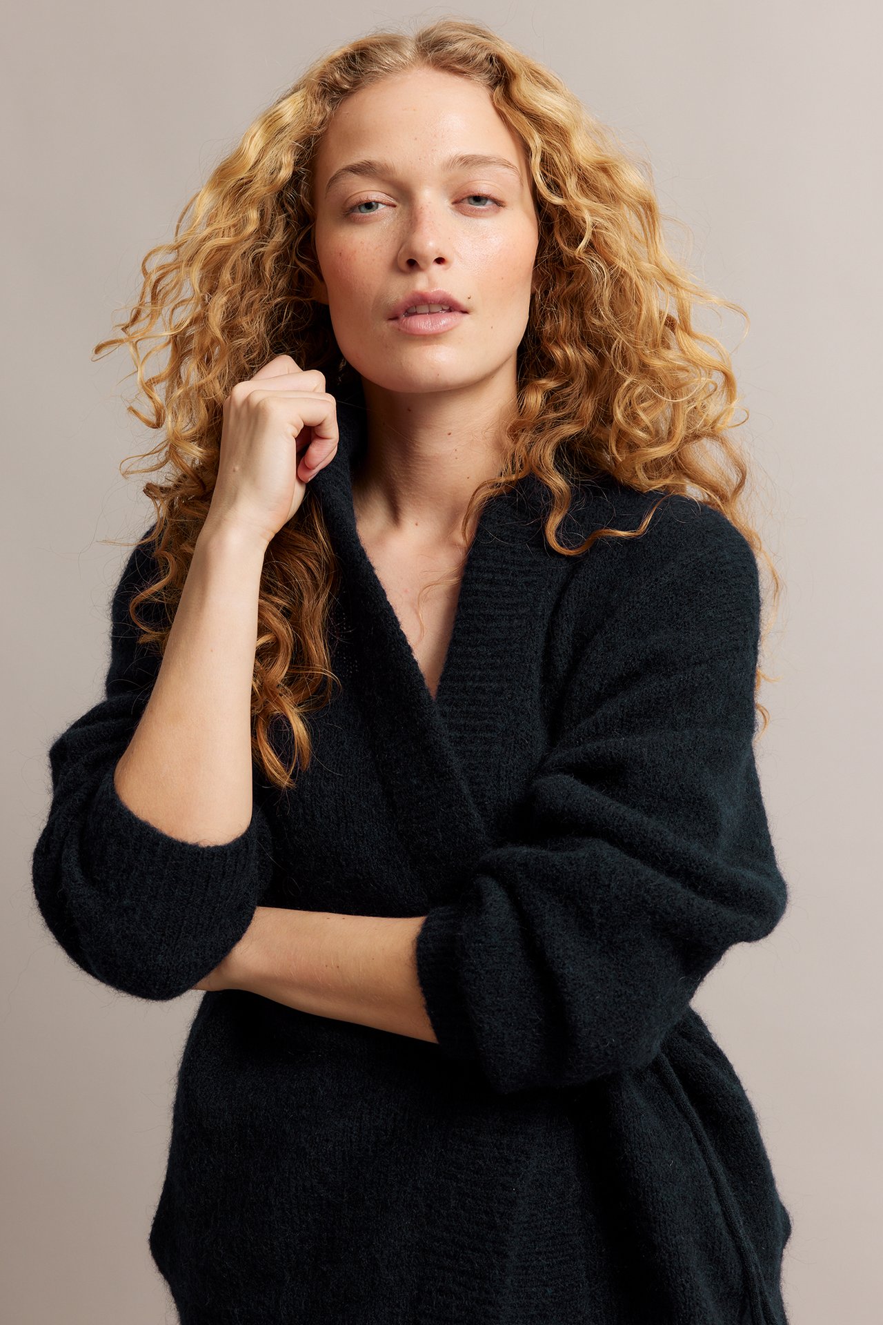 Naisen etunäkymä tummansinisessä villasekoitetakissa, jossa on solmimisvyö ja pehmeä pinta.