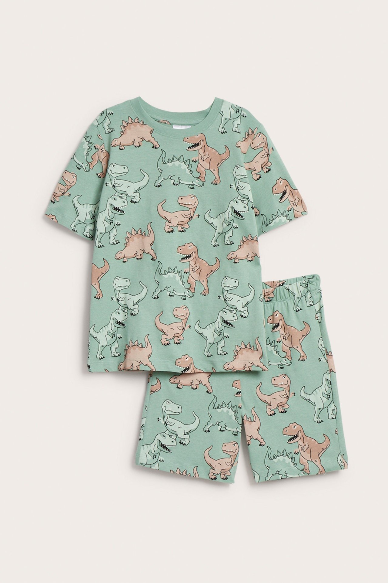 Edestä näkymä lasten vihreästä puuvillapyjamasetistä, jossa on dinosauruskuvio, lyhythihainen paita ja shortsit.