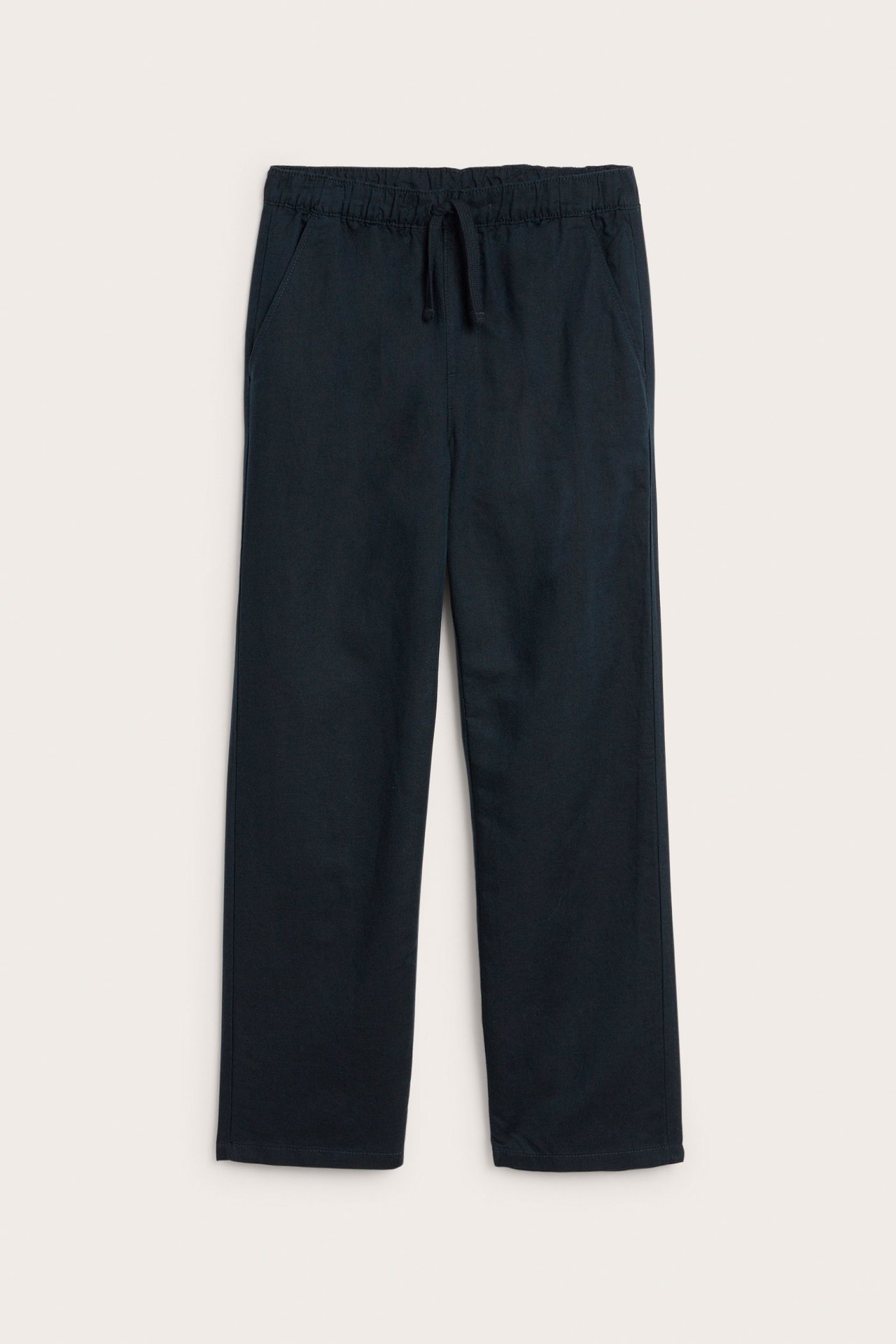 Widok z przodu ciemnoniebieskich spodni z mieszanki lnu, z elastyczną talią ze sznurkiem i bocznymi kieszeniami.