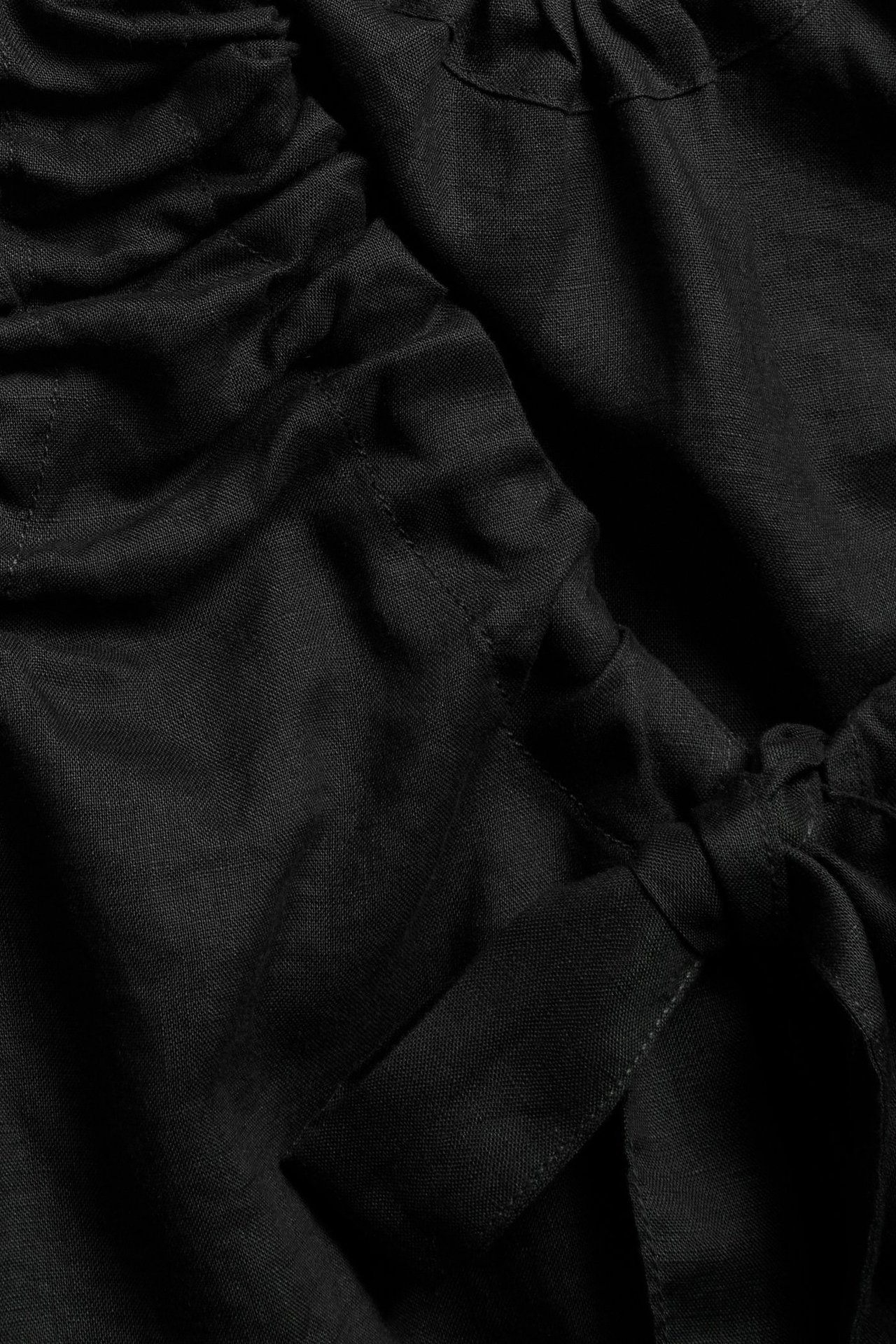 Zbliżenie czarnego lnianego topu ze sznurkiem i zawiązaną opaską z tkaniny.