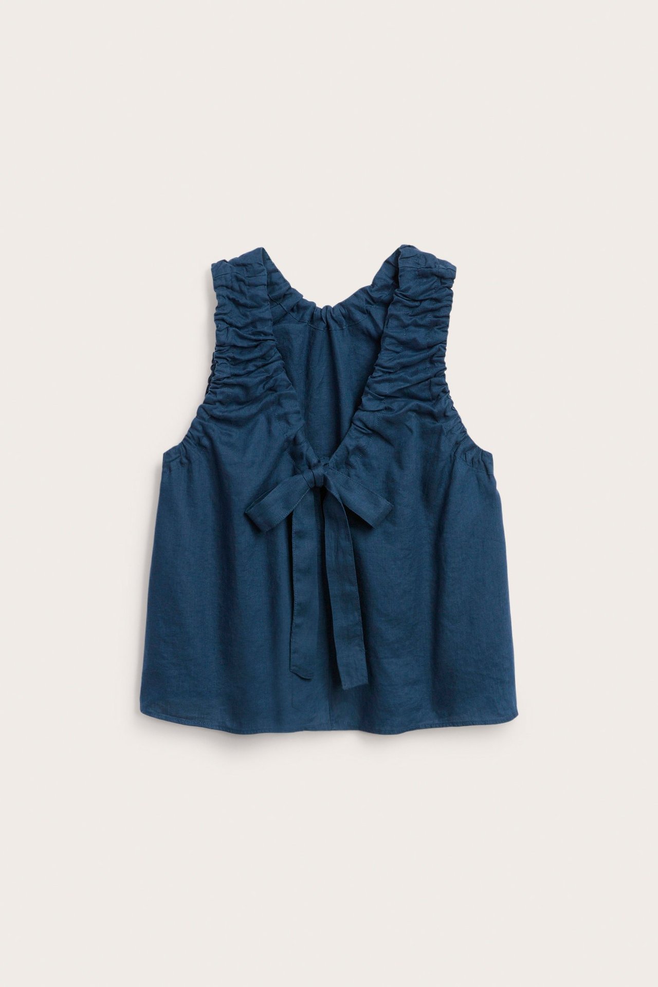 Widok z tyłu na niebieski lniany top z marszczonymi ramiączkami i wiązaniem na plecach.