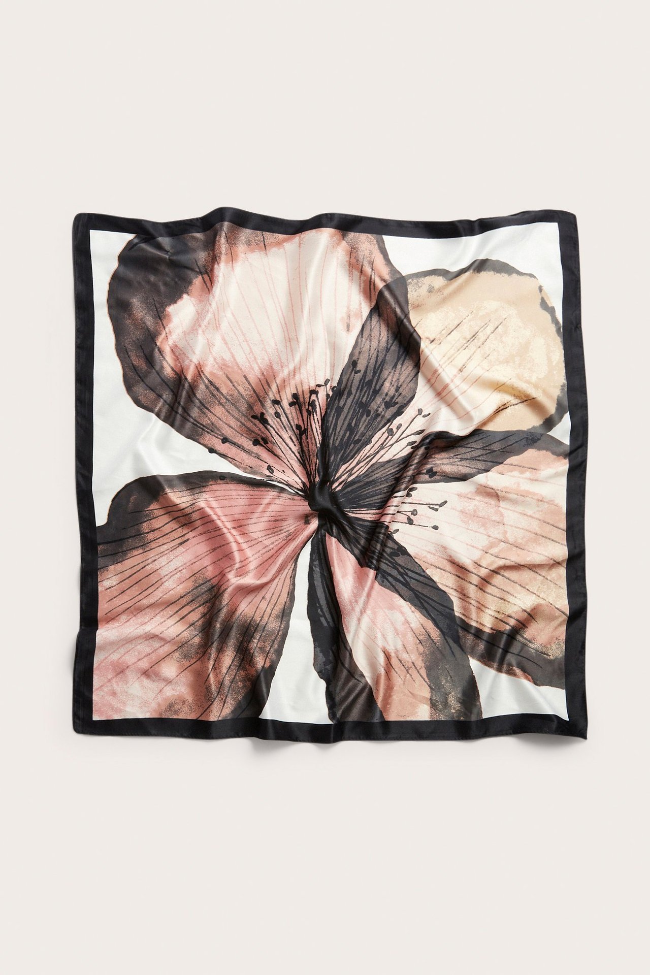 Topputsikt av et lyserosa og svart blomstermønstret firkantet polyester-skjerf med svart kant.