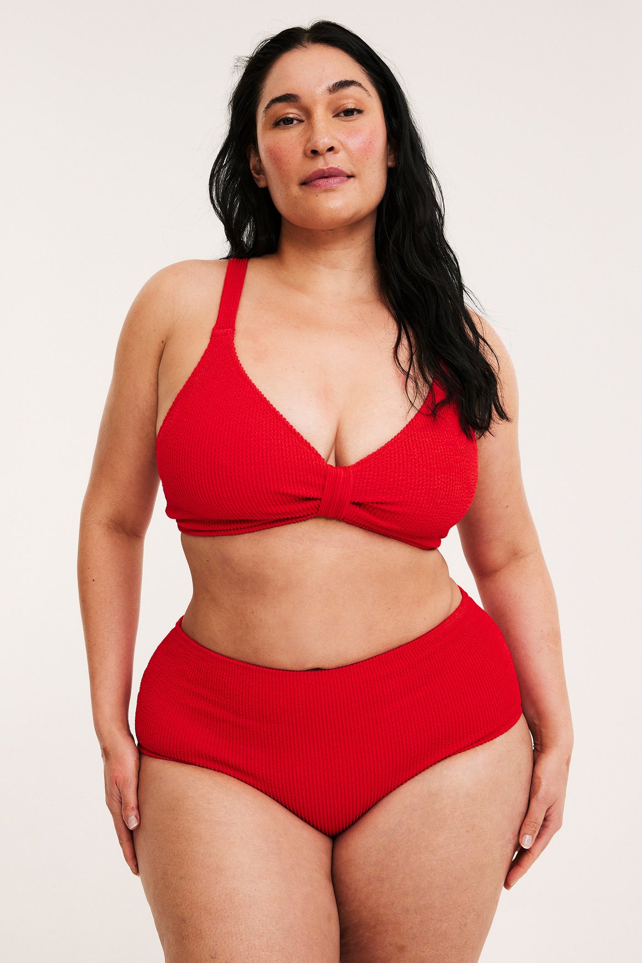 Edestäpäin, nainen yllään punaiset kuvioidut hipster-bikinialaosat ja vastaava punainen bikinin yläosa.