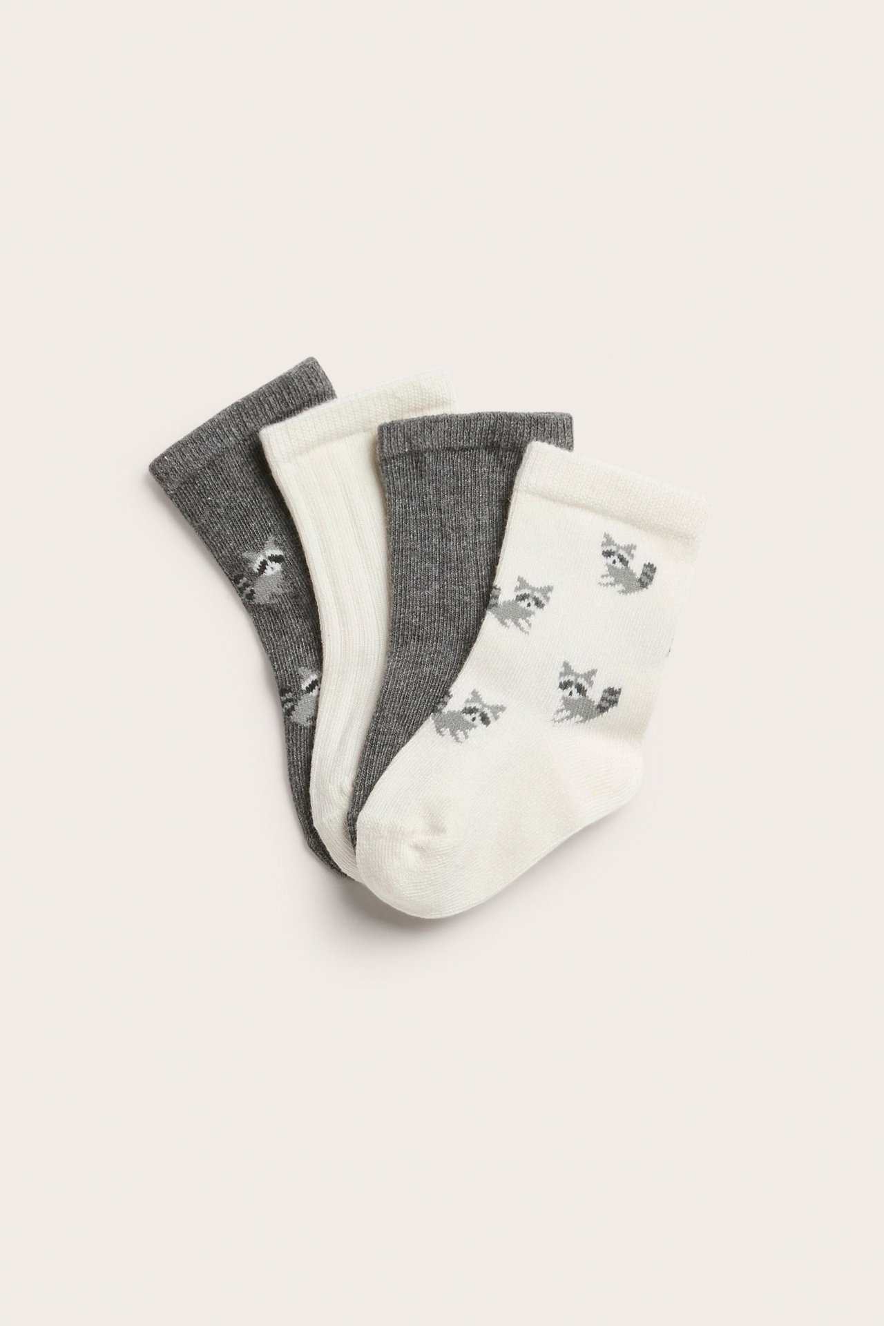 Fire par babysokker: to grå, ett ribbestrikket off-white, ett off-white med vaskebjørnmønster.