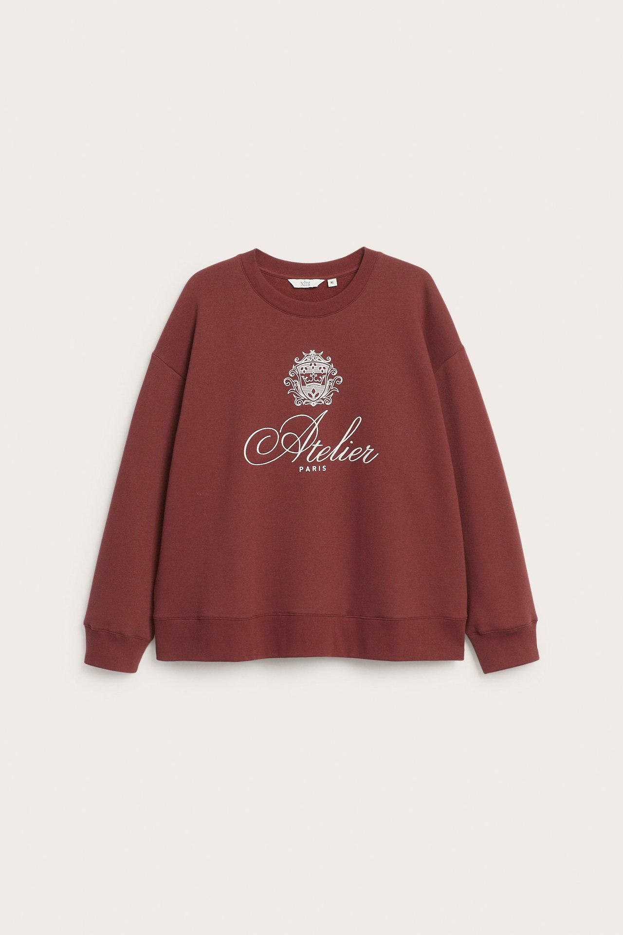 Widok z przodu czerwonej bluzy z mieszanki bawełny z białym nadrukiem 'Atelier Paris' i emblematem.