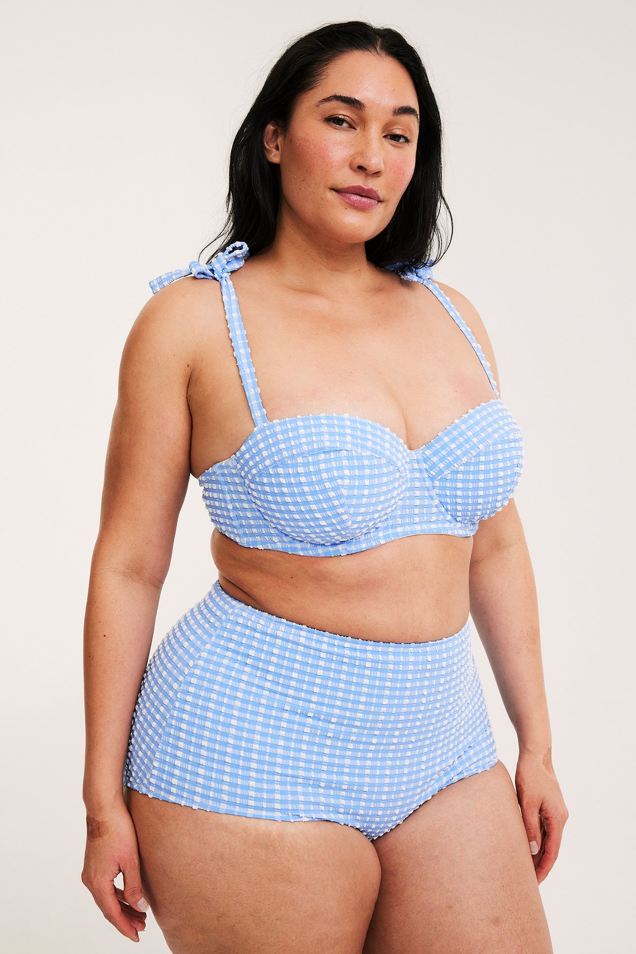 Forfra: kvinne i blå- og hvitrutete high hipster bikinitruse og matchende bikinitopp.