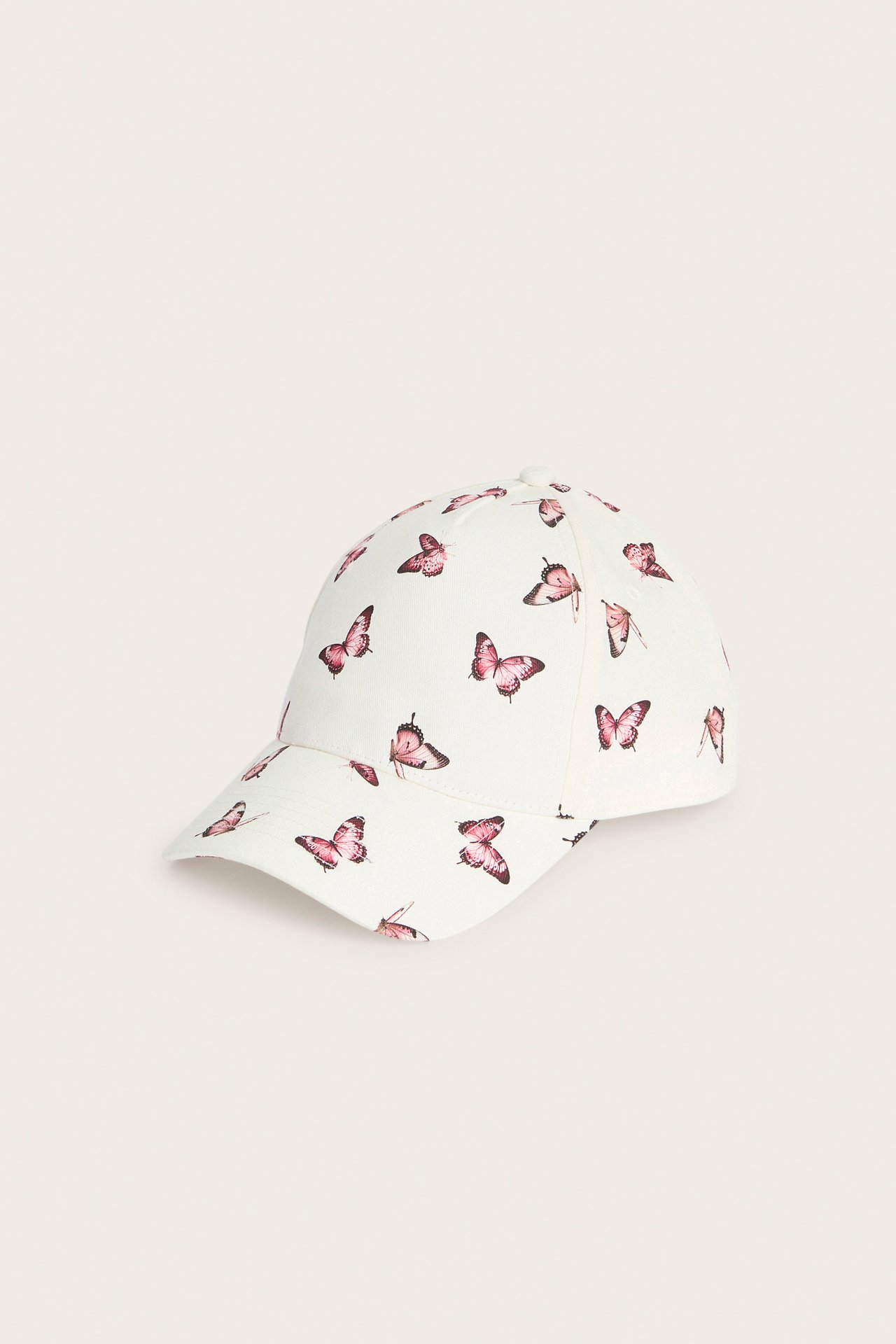 Off-white czapka z daszkiem z różowym wzorem motyli, widok z boku.