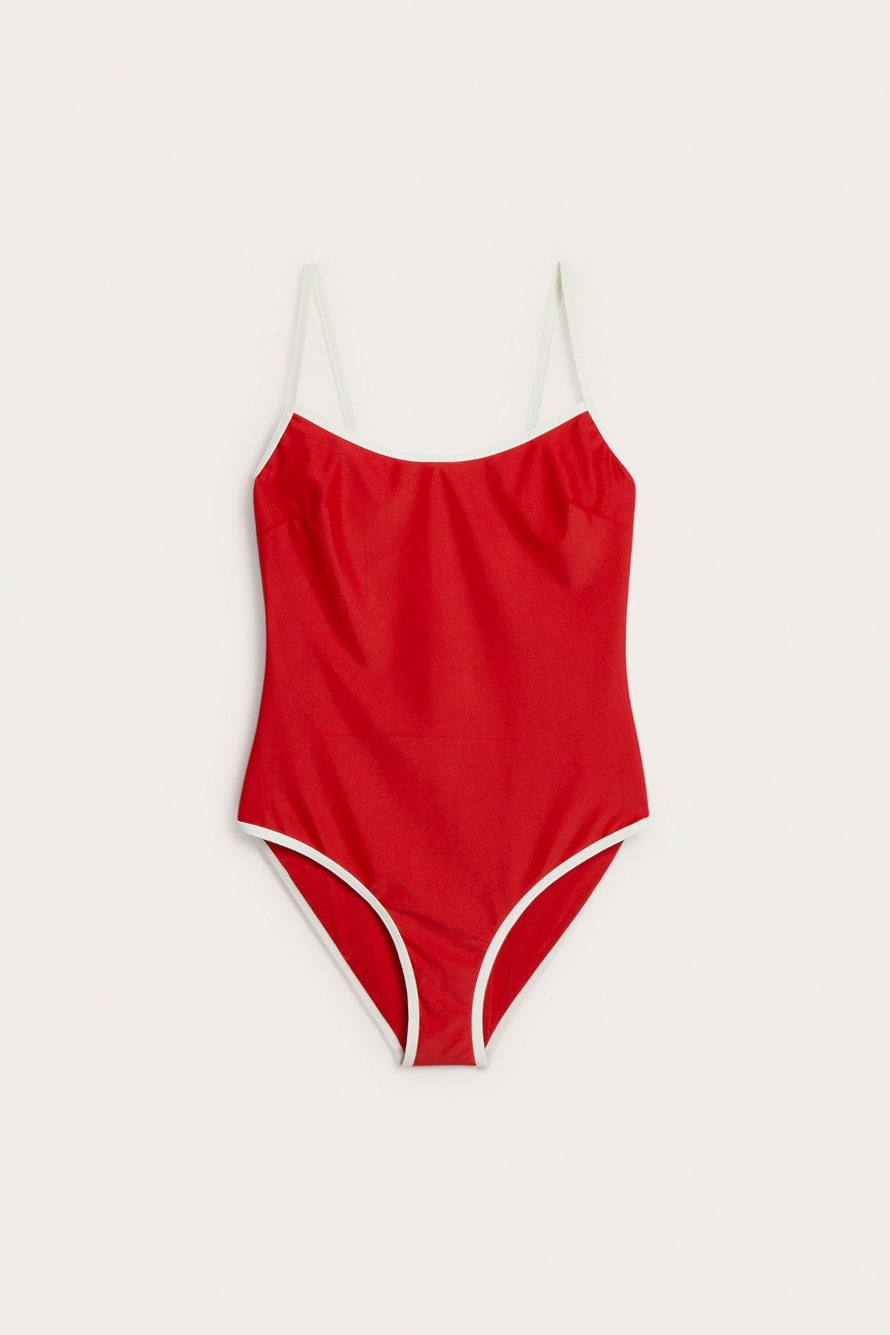 Framifrån: röd high-leg baddräkt med tunna axelband och ljusa kontrasterande kanter.
