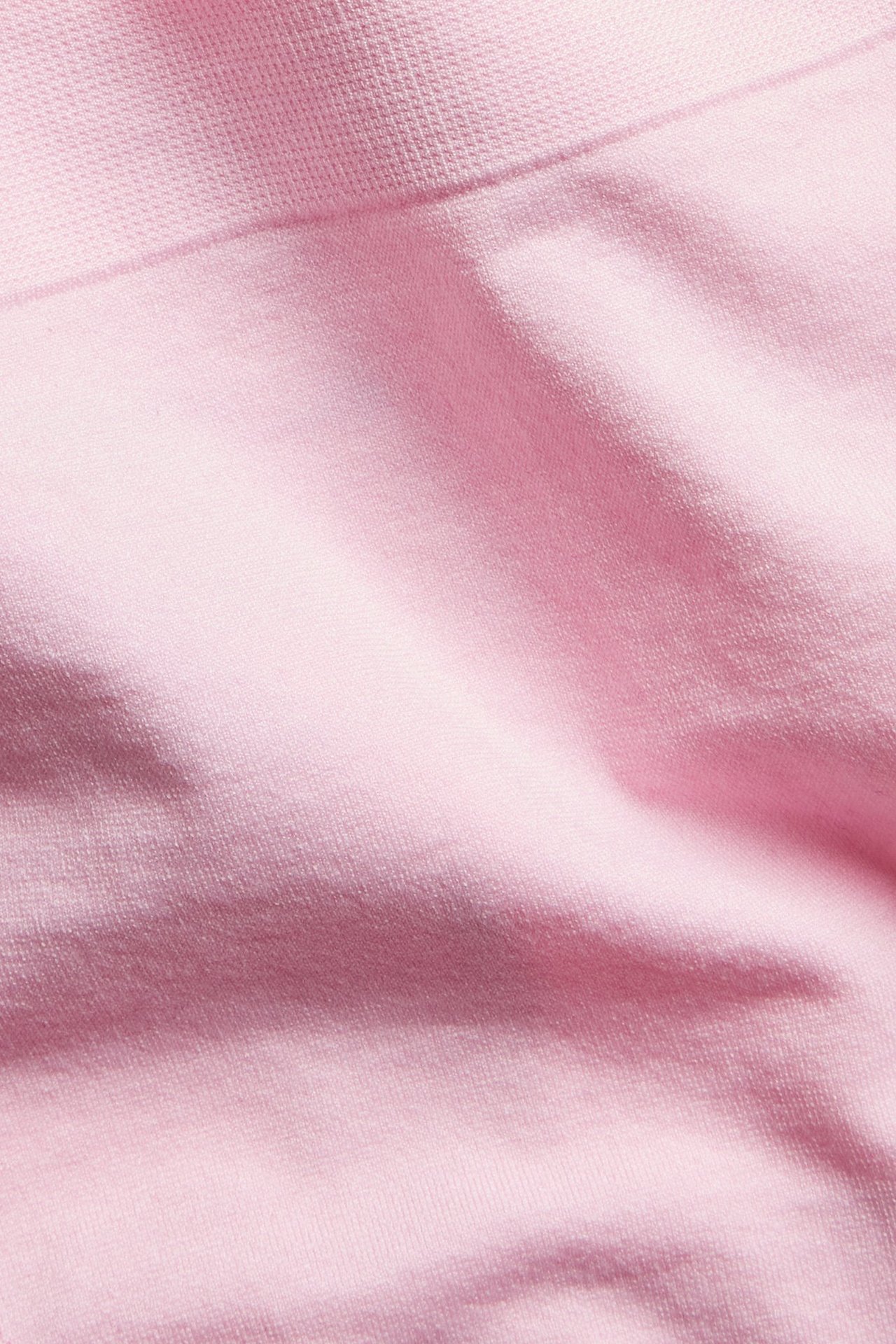 Zbliżenie różowych, bezszwowych stringów wykonanych z gładkiej, jednolitej tkaniny poliamidowej.