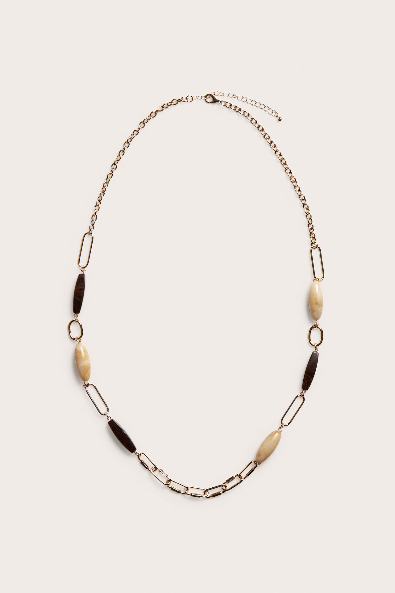 Widok z góry: Złoty naszyjnik z beżowymi i brązowymi kamieniami, mieszanymi ogniwami łańcucha.