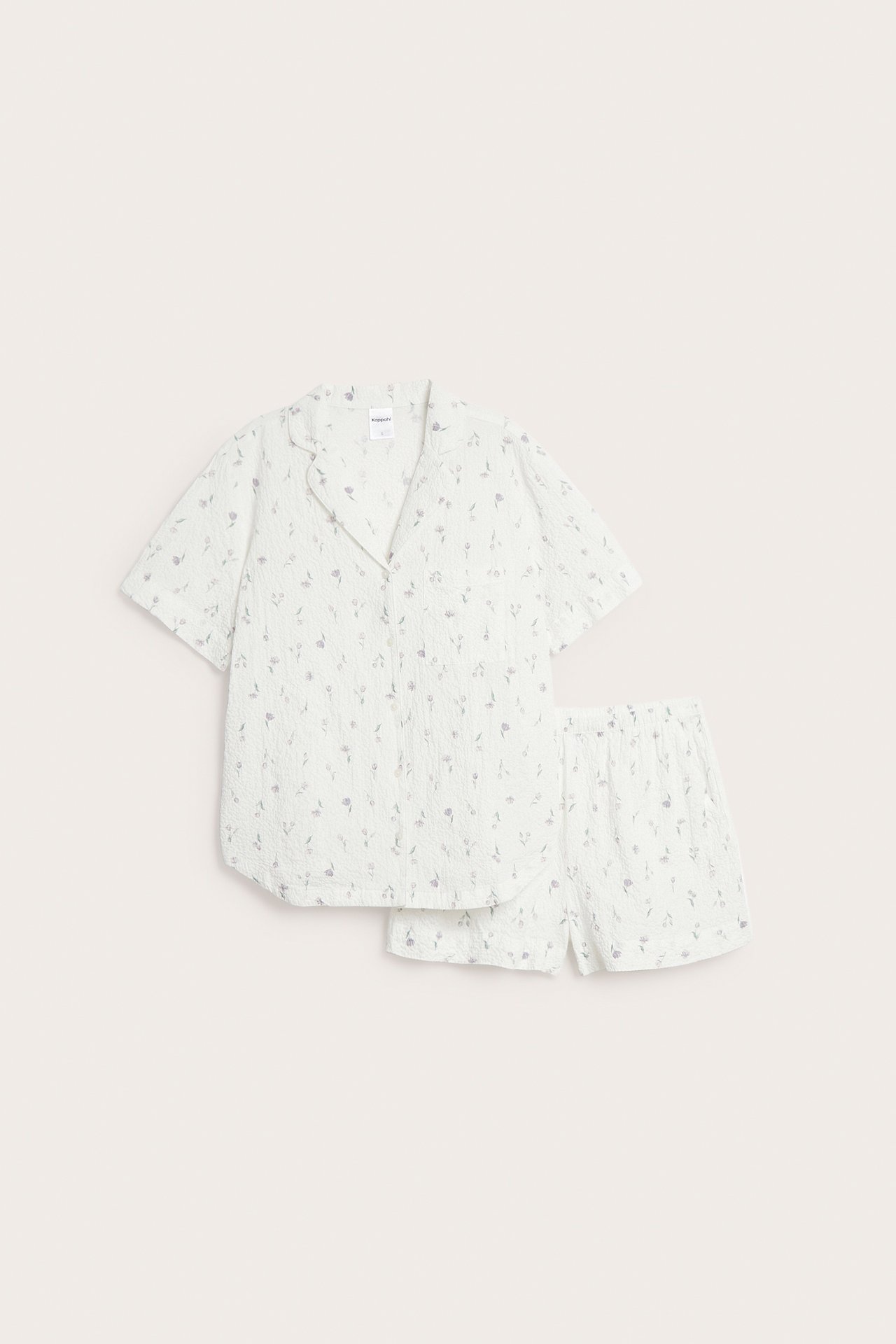 Forfra: Off-white kreppet pyjamasett, med blomstermønstret kortarmet skjorte og matchende shorts.