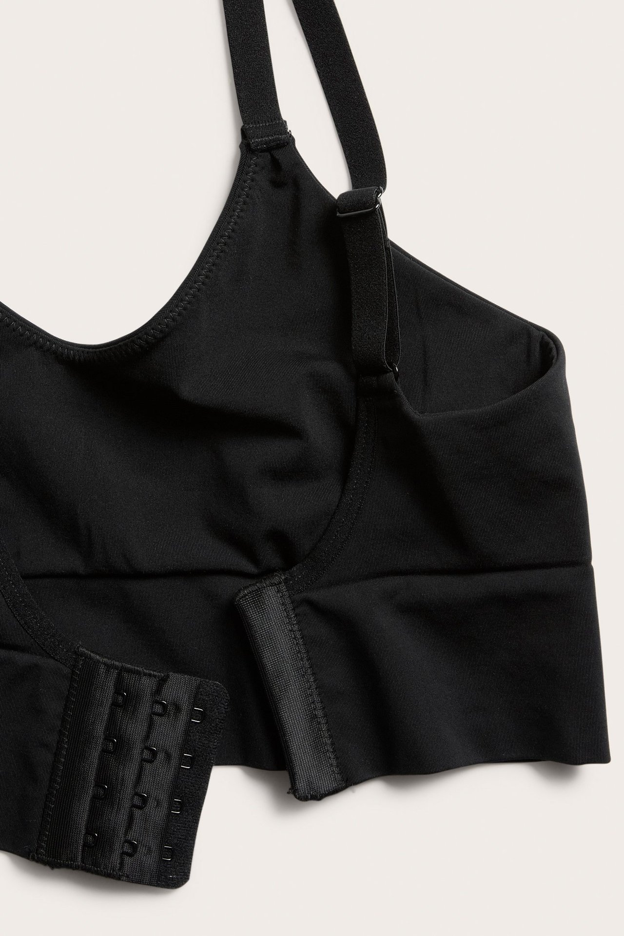 Lähikuva mustasta saumattomasta rintaliivistä säädettävillä olkaimilla ja nelirivisellä hakaskiinnityksellä.