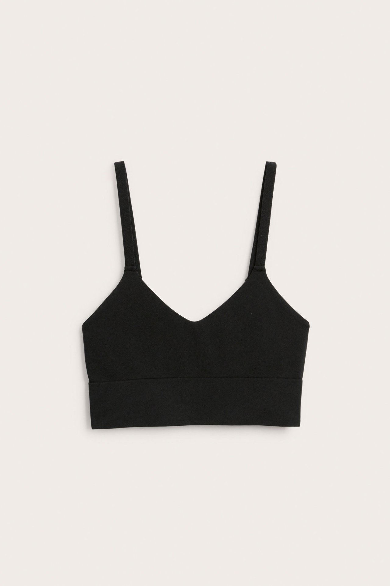 Edestä musta saumaton pehmeä rintaliivi ohuilla olkaimilla ja V-pääntiellä.